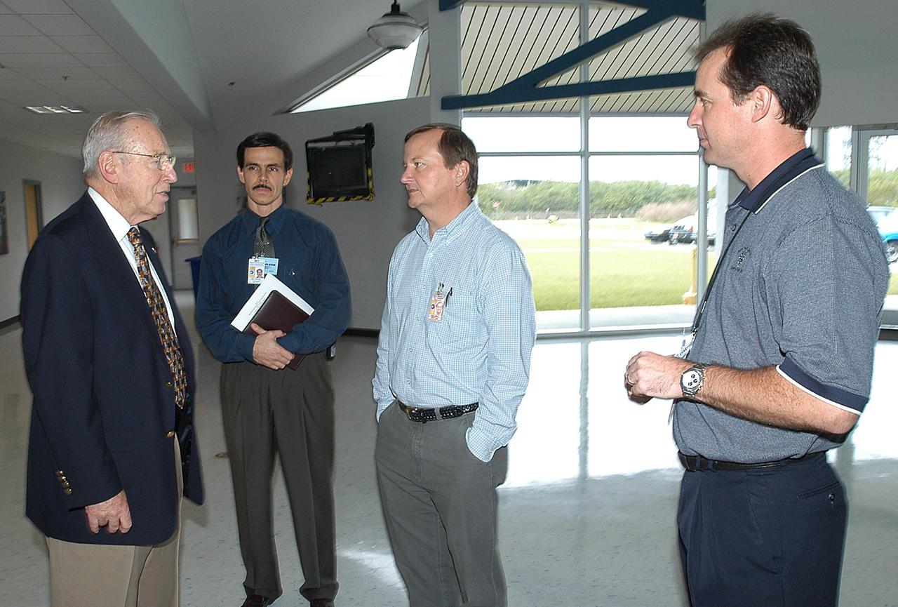 KENNEDY SPACE CENTER, FLA. - During a visit to KSC, former astronaut Jim Lovell (far left) talks to (from right) Space Shuttle Test Director Steve Altemus, Launch Director Mike Leinbach, and reconstruction engineer John Cowart.  Lovell, along with former astronaut Wally Schirra, visited KSC to talk about the space program and their experiences, as well as offer encouragement to workers to help get the space program "back on its feet."  They visited several sites around the Center, including the RLV Hangar where Columbia debris is being collected and examined as part of the investigation into the tragedy that claimed the orbiter and lives of seven astronauts returning from mission STS-107.