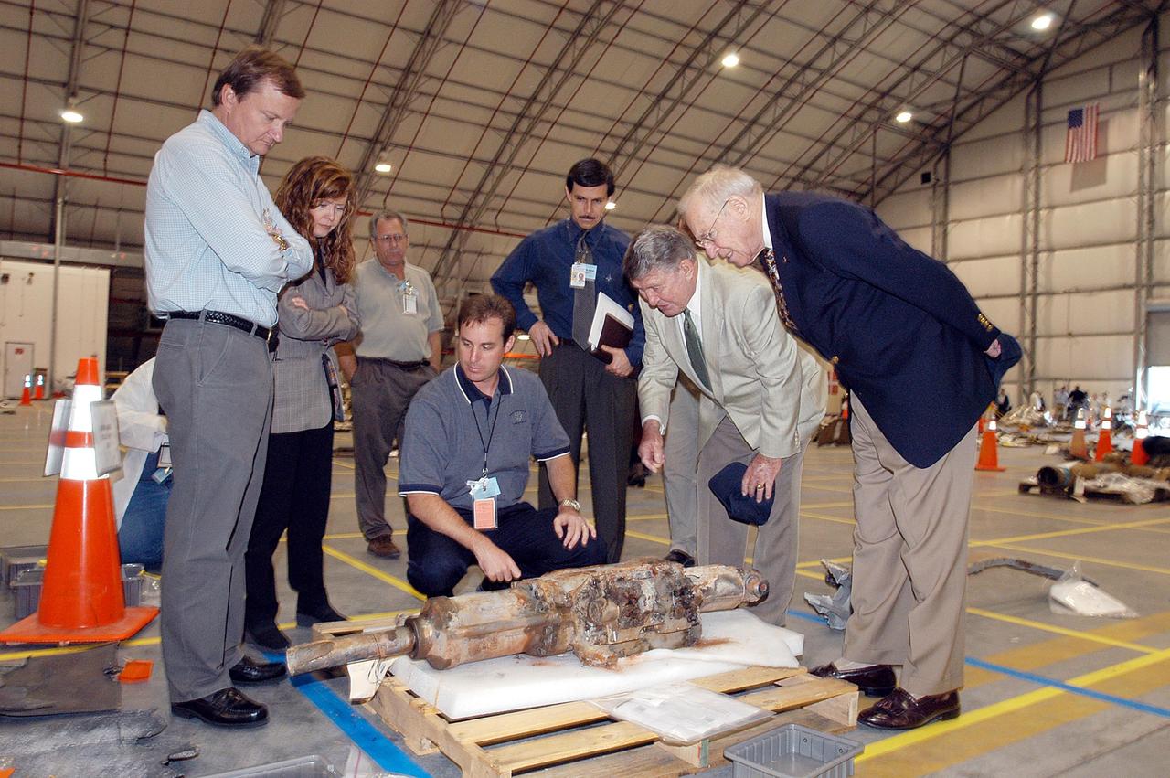KENNEDY SPACE CENTER, FLA. -  In the RLV Hangar, looking over a piece of Columbia debris are (from left) Launch Director Mike Leinbach, Acting Deputy Director of External Relations & Business Development Lisa Malone, Space Shuttle Test Director Steve Altemus, reconstruction engineer John Cowart, and former astronauts Wally Schirra and Jim Lovell.  The latter two visited several sites around the Center, encouraging workers to help get the space program "back on its feet."  The RLV Hangar is where Columbia debris is being collected and examined as part of the investigation into the tragedy that claimed the orbiter and lives of seven astronauts returning from mission STS-107.