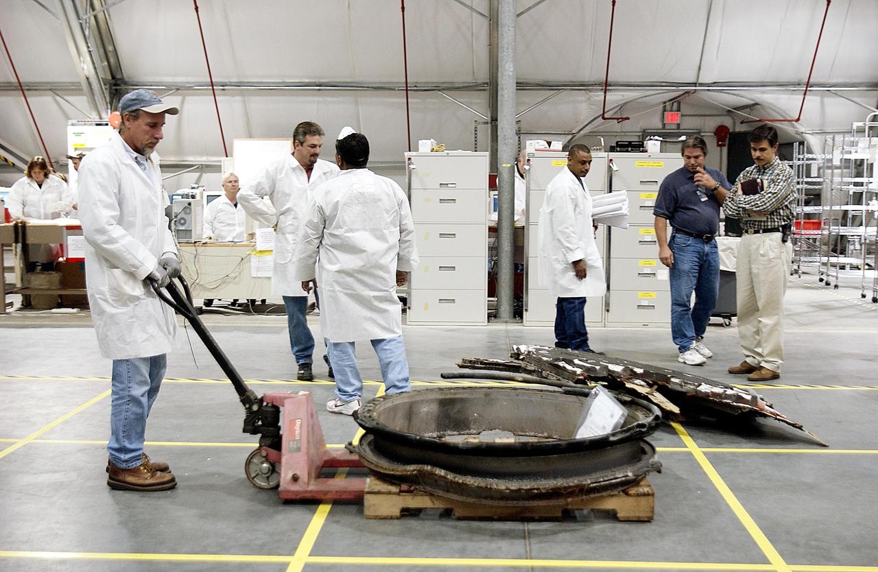 KENNEDY SPACE CENTER, FLA. -- Members of the Columbia Reconstruction Project Team move a piece of Columbia debris across the grid in the RLV Hangar.  The team is examining Columbia materials and will attempt to reconstruct the orbiter as part of the investigation into the accident that caused the destruction of Columbia and loss of its crew as it returned to Earth on mission STS-107.