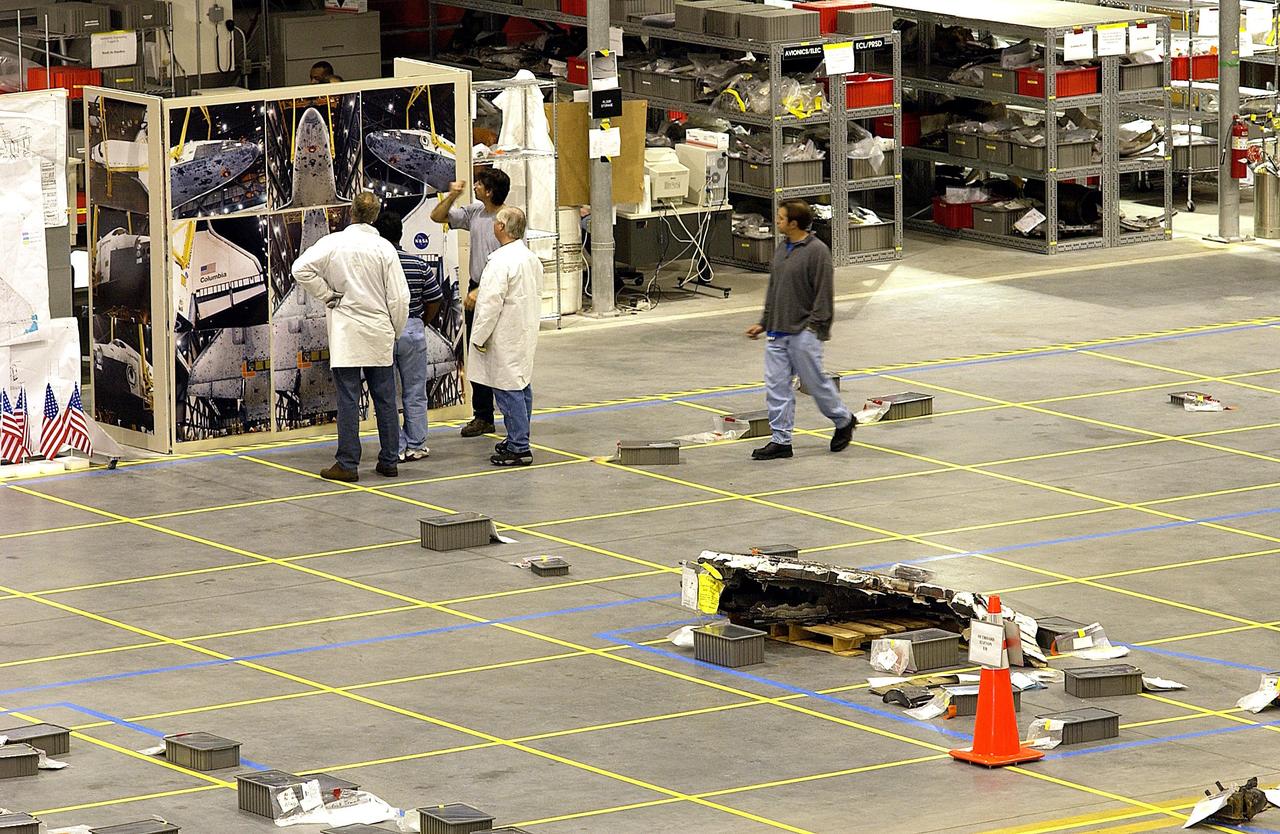 KENNEDY SPACE CENTER, FLA. -- In the RLV Hangar, members of the Columbia Reconstruction Project Team look at a stack of Columbia debris shipped from Barksdale AFB, Shreveport, La.  Barksdale continues to be the receiving and shipping point for Columbia materials being sent to KSC for final identification.  The team is attempting to reconstruct the orbiter as part of the investigation into the accident that caused the destruction of Columbia and loss of its crew as it returned to Earth on mission STS-107.