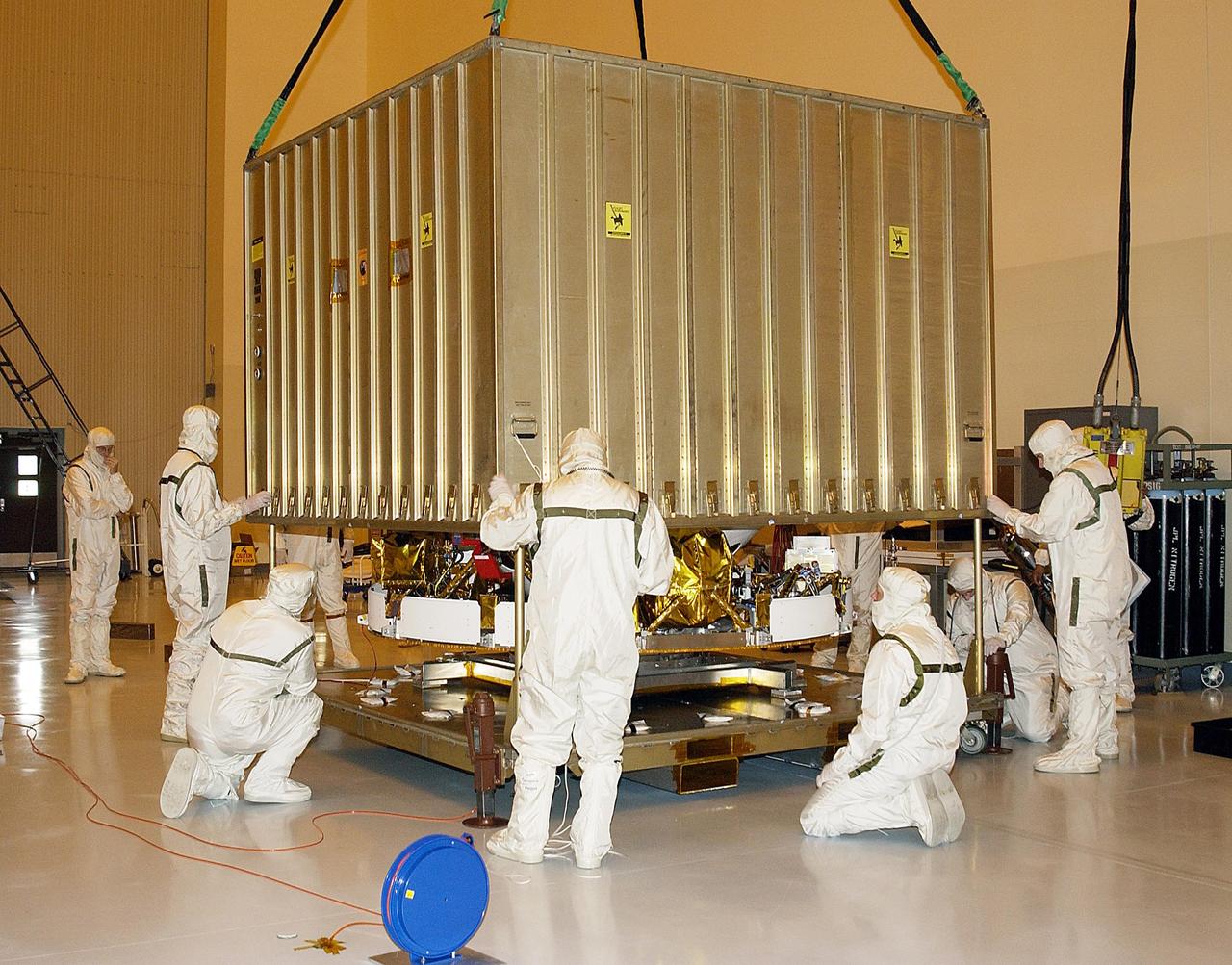 KENNEDY SPACE CENTER, FLA. - In the Payload Hazardous Servicing Facility, the shipping container is lifted off the components of Mars Exploration Rover-1, the aershell and cruise stage. Each rover , aeroshell and lander will undergo a full mission simulation while at KSC.  All flight elements will then be integrated.  After spin balance testing, each spacecraft will be mated to a solid propellant upper stage booster that will propel it out of Earth orbit. The rovers will serve as robotic geologists to seek answers about the evolution of Mars, particularly  for a history of water. The rovers will be identical to each other, but will land at different regions of Mars.  Launch of the MER-1 is scheduled for May 30.  MER-2 will follow June 25.