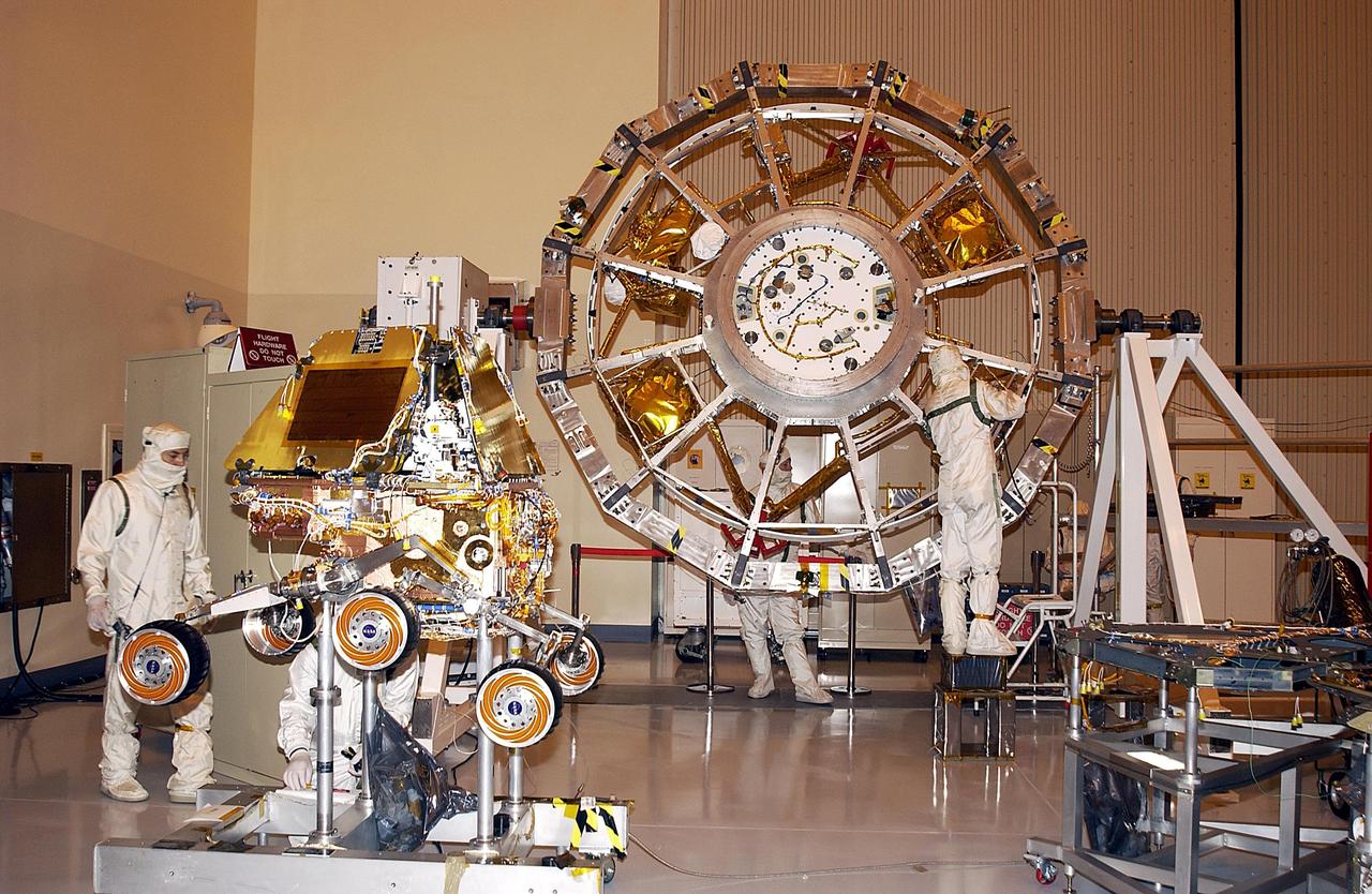 KENNEDY SPACE CENTER, FLA. --  Components of the flight hardware for Mars Exploration Rover-1 are in the Payload Hazardous Servicing Facility.  At left is the rover.  In the center is the cruise stage, which includes elements such as the thruster clusters, launch vehicle adapter and cruise electronics module. Each rover , aeroshell and lander will undergo a full mission simulation while at KSC.  All flight elements will then be integrated.  After spin balance testing, each spacecraft will be mated to a solid propellant upper stage booster that will propel it out of Earth orbit.  The rovers will serve as robotic geologists to seek answers about the evolution of Mars, particularly  for a history of water. The rovers will be identical to each other, but will land at different regions of Mars.  Launch of the MER-1 is scheduled for May 30.  MER-2 will follow June 25.
