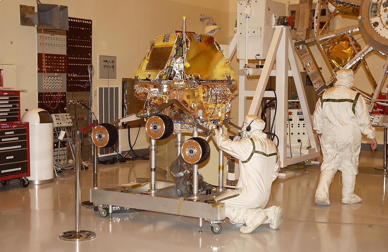 KENNEDY SPACE CENTER, FLA. -- A worker in the Payload Hazardous Servicing Facility examines the Mars Exploration Rover-2.The rover , aeroshell and lander will undergo a full mission simulation while at KSC.  All flight elements will then be integrated.  After spin balance testing, each spacecraft will be mated to a solid propellant upper stage booster that will propel it out of Earth orbit.  The rovers will serve as robotic geologists to seek answers about the evolution of Mars, particularly  for a history of water. The rovers will be identical to each other, but will land at different regions of Mars.  Launch of the MER-1 is scheduled for May 30.  MER-2 will follow June 25.