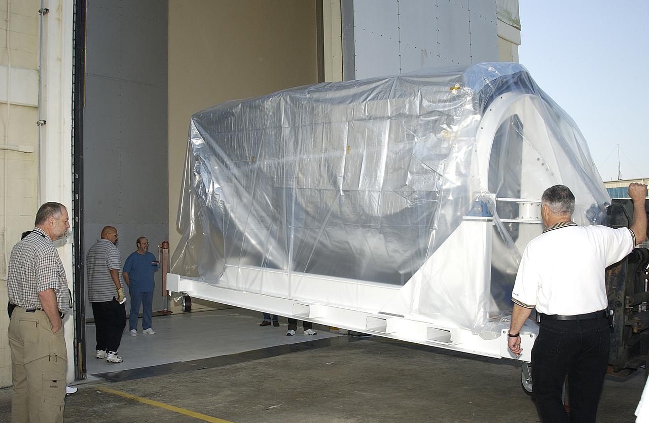 The Space Infrared Telescope Facility (SIRTF) arrives at Building AE from the Lockheed Martin plant in Sunnyvale, Calif., to begin final preparations for its launch aboard a Delta II rocket. SIRTF will obtain images and spectra by detecting the infrared energy, or heat, radiated by objects in space. Most of this infrared radiation is blocked by the Earth's atmosphere and cannot be observed from the ground. Consisting of an 0.85-meter telescope and three cryogenically cooled science instruments, SIRTF is one of NASA's largest infrared telescopes to be launched. SIRTF is scheduled for launch April 15 at 4:34:07 a.m. EDT from Launch Complex 17-B, Cape Canaveral Air Force Station.