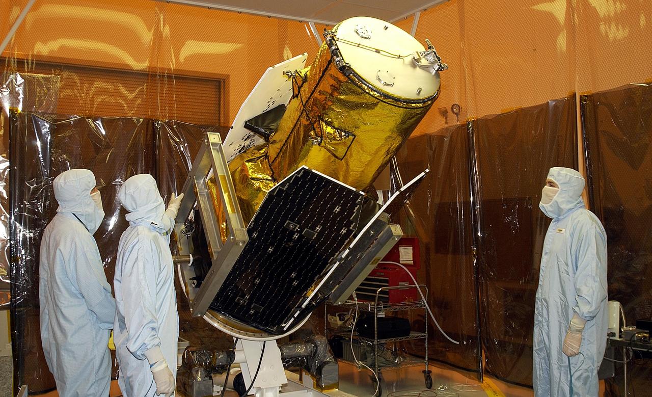 KENNEDY SPACE CENTER, FLA. - Workers in the Multi-Payload Processing Facility watch as NASA's Galaxy Evolution Explorer spacecraft is rotated in preparation for mating with the Pegasus XL launch vehicle. The GALEX, set to launch April 2 from Cape Canaveral Air Force Station, will carry into space an orbiting telescope that will observe a million galaxies across 10 billion years of cosmic history to help astronomers determine when the stars and elements we see today had their origins. From its orbit high above Earth, the spacecraft will sweep the skies for 28 months using state-of-the-art ultraviolet detectors.  Looking in the ultraviolet will single out galaxies dominated by young, hot, short-lived stars that give off a great deal of energy at that wavelength.  These galaxies are actively creating stars, and therefore provide a window into the history and causes of star formation in galaxies.