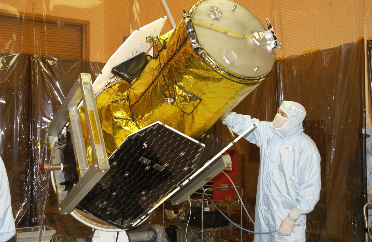 KENNEDY SPACE CENTER, FLA. -A worker in the Multi-Payload Processing Facility watches closely as NASA's Galaxy Evolution Explorer spacecraft is rotated in preparation for mating with the Pegasus XL launch vehicle. The GALEX, set to launch April 2 from Cape Canaveral Air Force Station, will carry into space an orbiting telescope that will observe a million galaxies across 10 billion years of cosmic history to help astronomers determine when the stars and elements we see today had their origins. From its orbit high above Earth, the spacecraft will sweep the skies for 28 months using state-of-the-art ultraviolet detectors.  Looking in the ultraviolet will single out galaxies dominated by young, hot, short-lived stars that give off a great deal of energy at that wavelength.  These galaxies are actively creating stars, and therefore provide a window into the history and causes of star formation in galaxies.