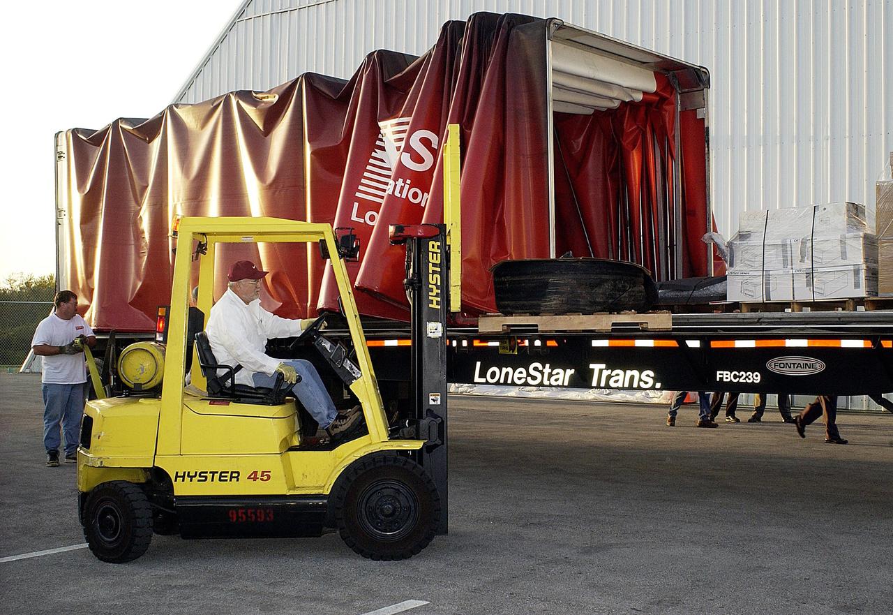 KENNEDY SPACE CENTER, FLA. - Another shipment of Columbia debris is being offloaded at the KSC RLV Hangar. Inside, the Columbia Reconstruction Project Team is identifying pieces and placing them on a floor grid in a configuration of the orbiter. The team will attempt to reconstruct the orbiter as part of the investigation into the accident that caused the destruction of Columbia and loss of its crew as it returned to Earth on mission STS-107.
