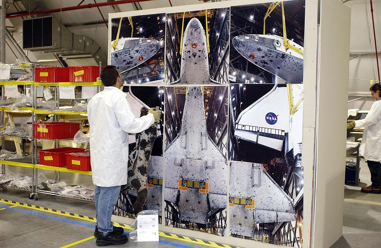 KENNEDY SPACE CENTER, FLA. - A member of the Columbia Reconstruction Project Team examines a graphic display of the orbiter in the KSC RLV Hangar. The team is attempting to identify the debris and reconstruct the orbiter as part of the investigation into the accident that caused the destruction of Columbia and loss of its crew as it returned to Earth on mission STS-107.