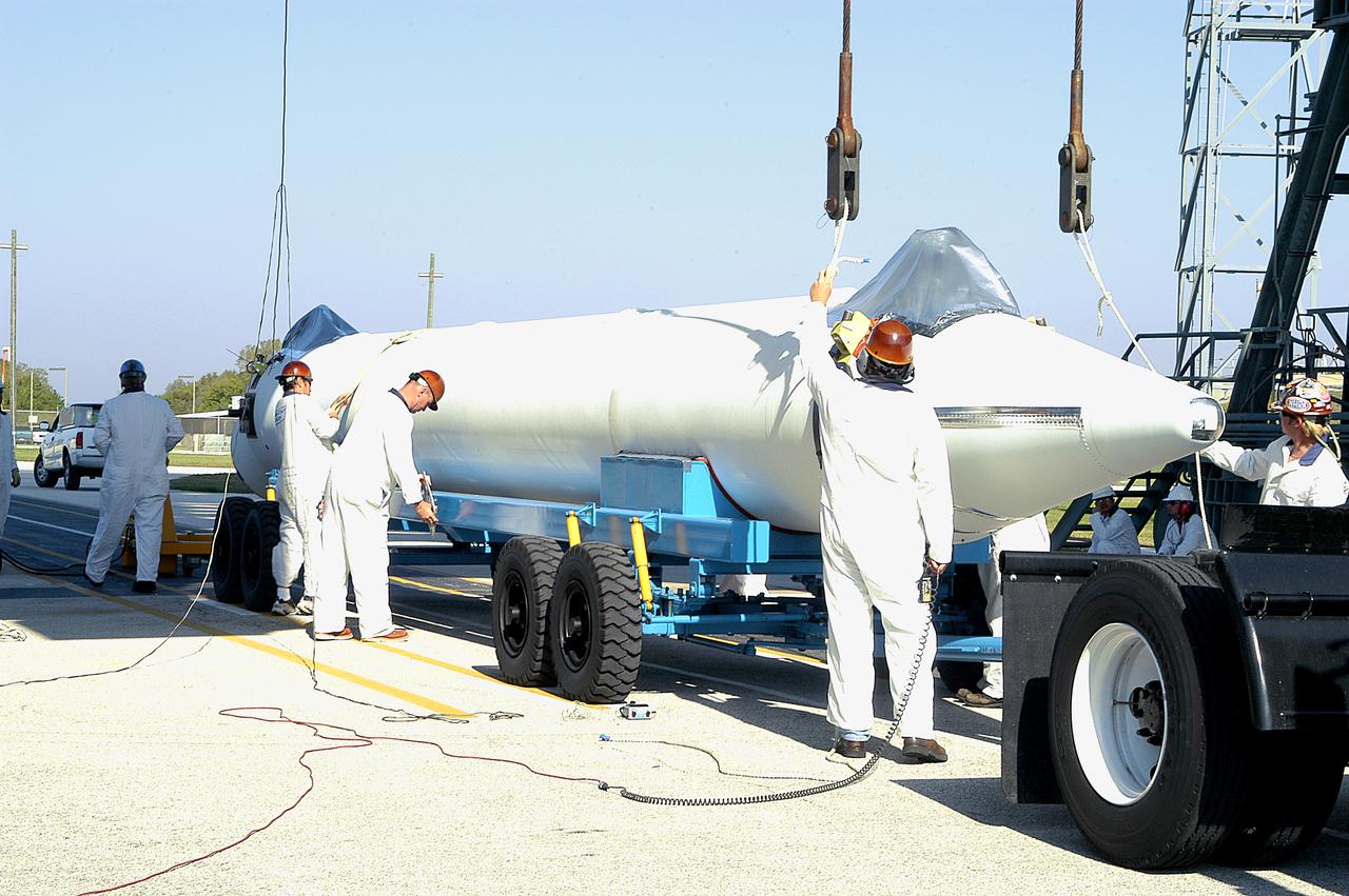 A booster rocket arrives at Launch Complex 17-B, Cape Canaveral Air Force Station. It is one of nine solid rocket boosters being erected and mated to the Delta II rocket for launch of the Space Infrared Telescope Facility. The second stage will later be hoisted atop the first stage. SIRTF will obtain images and spectra by detecting the infrared energy, or heat, radiated by objects in space. Most of this infrared radiation is blocked by the Earth's atmosphere and cannot be observed from the ground. Consisting of an 0.85-meter telescope and three cryogenically cooled science instruments, SIRTF is one of NASA's largest infrared telescopes to be launched. SIRTF is scheduled for launch April 15 at 4:34:07 a.m. EDT. 