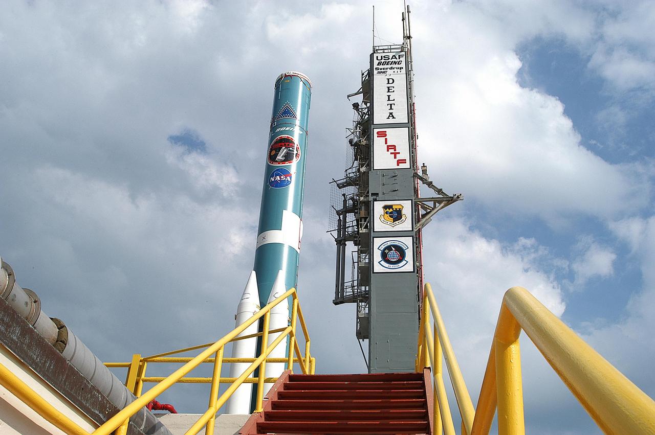 KENNEDY SPACE CENTER, FLA. - The Delta II rocket on Launch Complex 17-B, Cape Canaveral Air Force Station, waits for additional solid rocket boosters to be mated.  The Delta II will launch the Space Infrared Telescope Facility. The second stage will later be hoisted atop the first stage.  SIRTF will obtain images and spectra by detecting the infrared energy, or heat, radiated by objects in space. Most of this infrared radiation is blocked by the Earth's atmosphere and cannot be observed from the ground. Consisting of an 0.85-meter telescope and three cryogenically cooled science instruments, SIRTF is one of NASA's largest infrared telescopes to be launched.