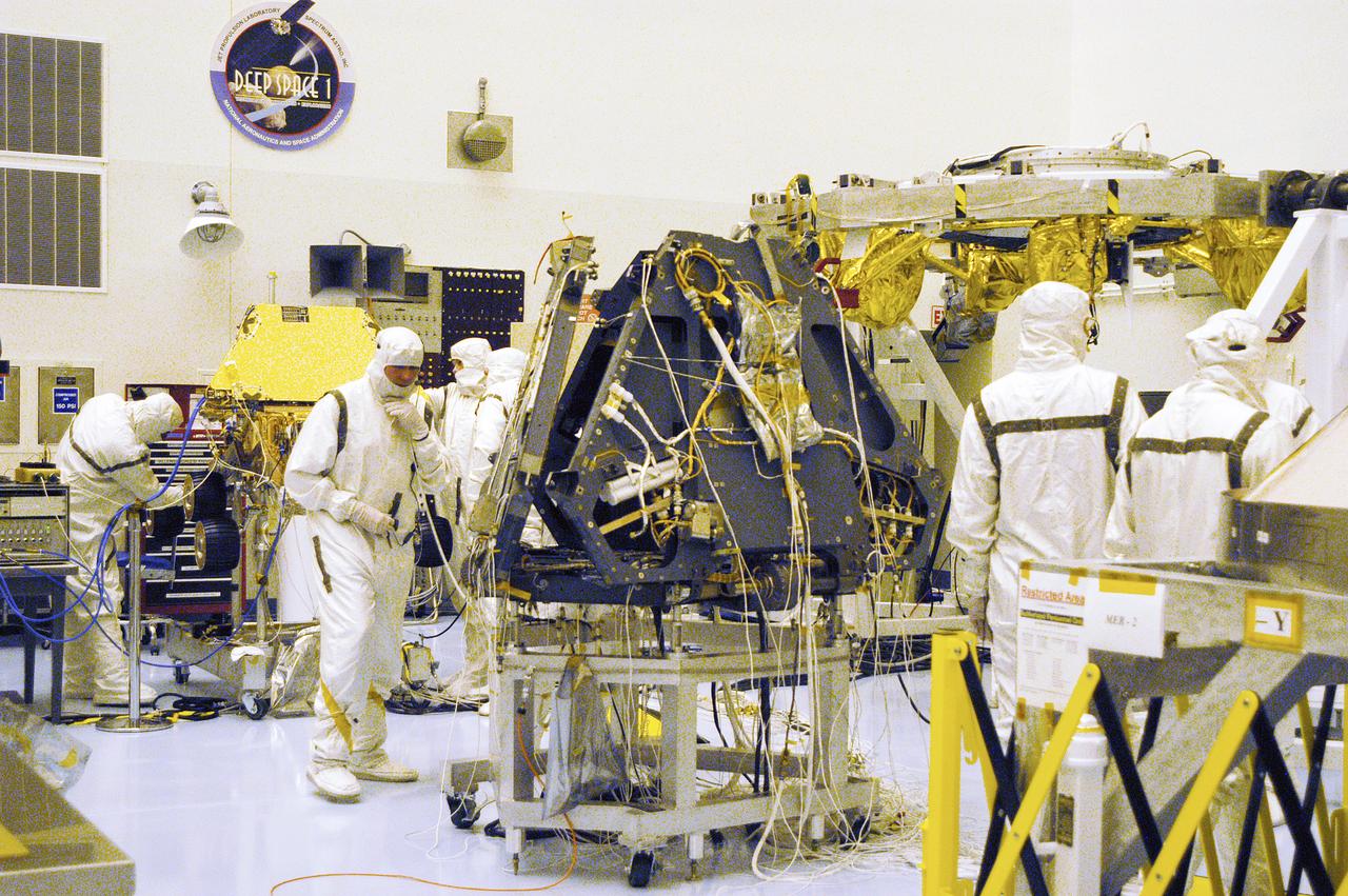 Technicians in the Payload Hazardous Servicing Facility work on components of the Mars Exploration Rovers. In the center is a lander. MER-1 and MER-2, their aeroshells and landers will undergo a full mission simulation before being integrated. After spin balance testing, each spacecraft will be mated to a solid propellant upper stage booster that will propel the spacecraft out of Earth orbit. Approximately 10 days before launch they will be transported to the launch pad for mating with their respective Boeing Delta II rockets. The rovers will serve as robotic geologists to seek answers about the evolution of Mars, particularly for a history of water. The rovers are identical to each other, but will land at different regions of Mars. Launch of the first rover is scheduled for May 30 from Cape Canaveral Air Force Station. The second will follow June 25.