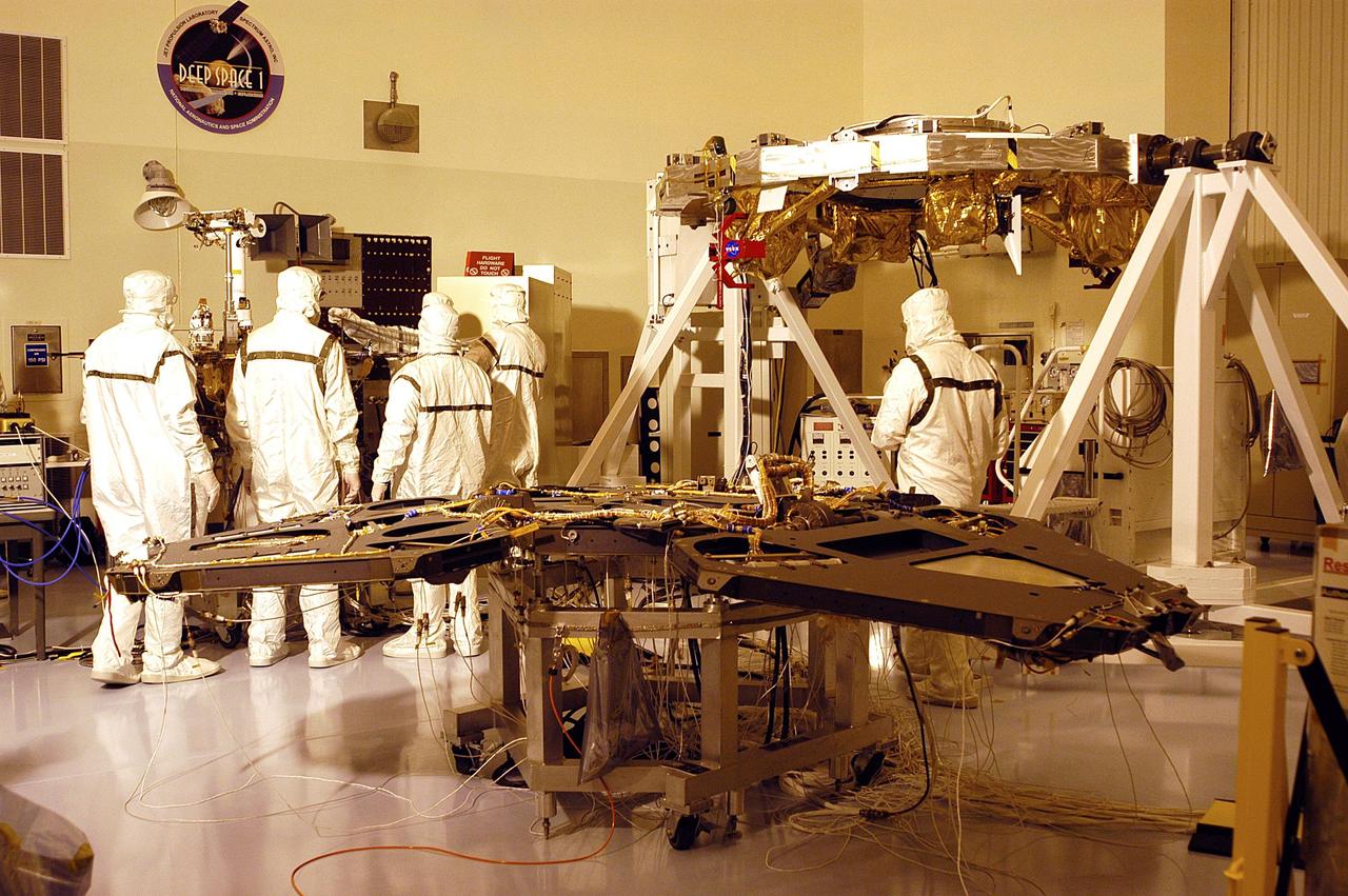 KENNEDY SPACE CENTER, Fla. - Components of the Mars Exploration Rovers are undergoing testing in the Payload Hazardous Servicing Facility.  In the foreground is a lander with its three side petals extended.  In the background is a cruise stage assembly.  The two rovers, MER-1 and MER-2, their aeroshells and landers will undergo a full mission simulation before being integrated. After spin balance testing,  each spacecraft will be mated to a solid propellant upper stage booster that will propel the spacecraft out of Earth orbit. Approximately 10 days before launch they will be transported to the launch pad for mating with their respective Boeing Delta II rockets. The rovers will serve as robotic geologists to seek answers about the evolution of Mars, particularly  for a history of water. The rovers are identical to each other, but will land at different regions of Mars.  Launch of the first rover is scheduled for May 30 from Cape Canaveral Air Force Station.  The second will follow June 25.
