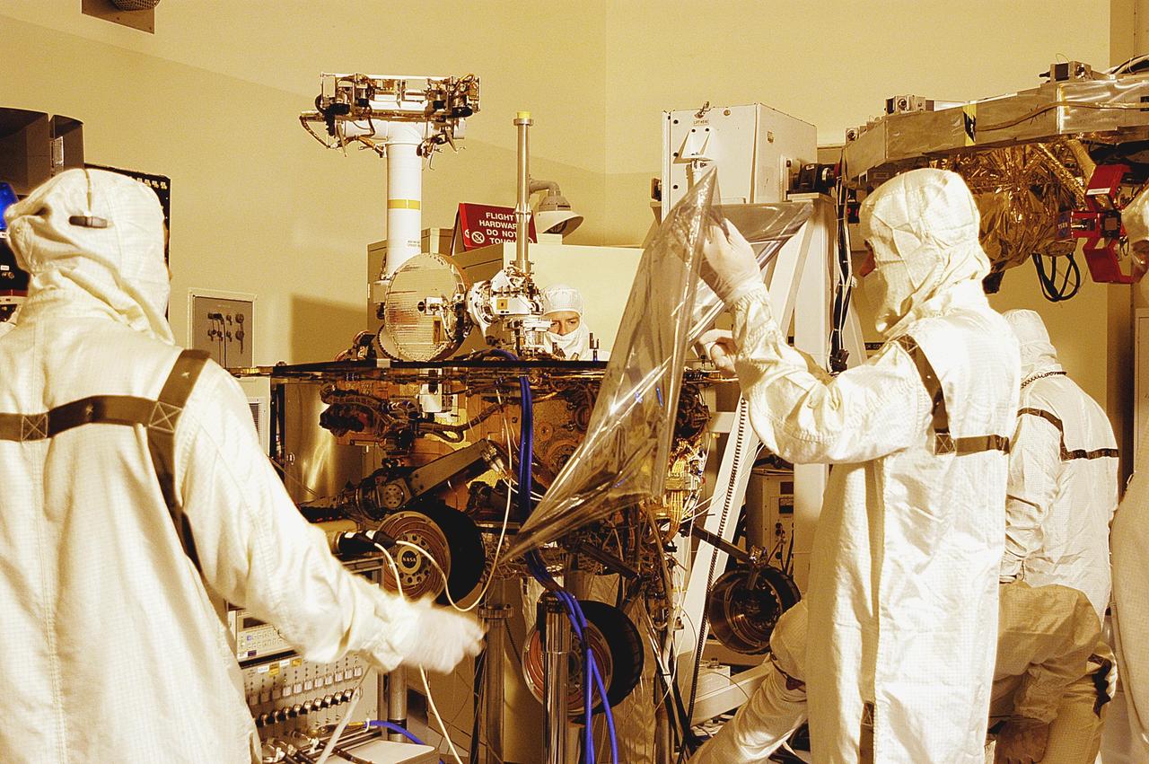 KENNEDY SPACE CENTER, Fla. -  Technicians in the Payload Hazardous Servicing Facility work on one of the Mars Exploration Rovers, MER-2.  The two rovers, MER-1 and MER-2, their aeroshells and landers will undergo a full mission simulation before being integrated. After spin balance testing,  each spacecraft will be mated to a solid propellant upper stage booster that will propel the spacecraft out of Earth orbit. Approximately 10 days before launch they will be transported to the launch pad for mating with their respective Boeing Delta II rockets. The rovers will serve as robotic geologists to seek answers about the evolution of Mars, particularly  for a history of water. The rovers are identical to each other, but will land at different regions of Mars.  Launch of the first rover is scheduled for May 30 from Cape Canaveral Air Force Station.  The second will follow June 25.