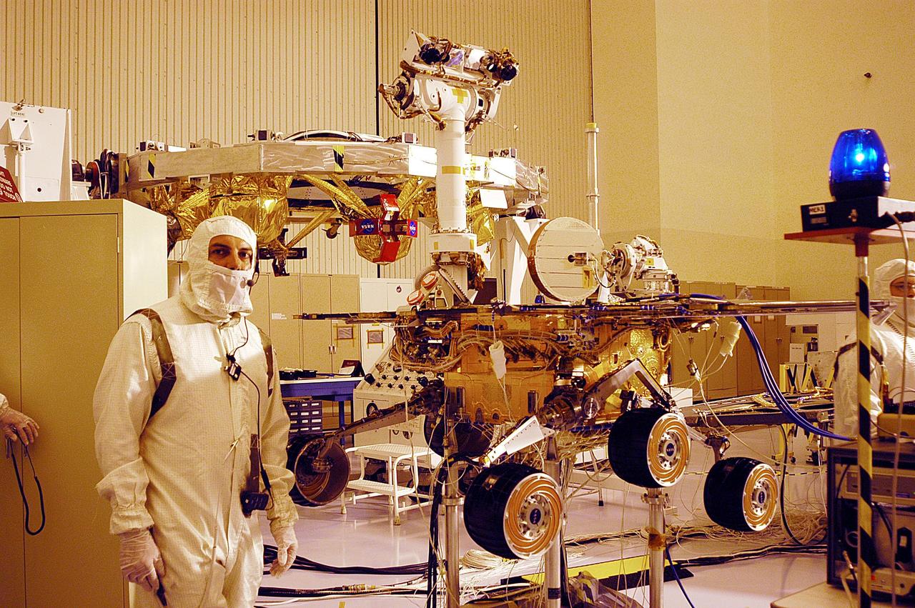 KENNEDY SPACE CENTER, Fla. -A worker in the Payload Hazardous Servicing Facility pauses during checkout of one of the two Mars Exploration Rovers, MER-2.  MER-1 and MER-2, their aeroshells and landers will undergo a full mission simulation before being integrated. After spin balance testing,  each spacecraft will be mated to a solid propellant upper stage booster that will propel the spacecraft out of Earth orbit. Approximately 10 days before launch they will be transported to the launch pad for mating with their respective Boeing Delta II rockets. The rovers will serve as robotic geologists to seek answers about the evolution of Mars, particularly  for a history of water. The rovers are identical to each other, but will land at different regions of Mars.  Launch of the first rover is scheduled for May 30 from Cape Canaveral Air Force Station.  The second will follow June 25.