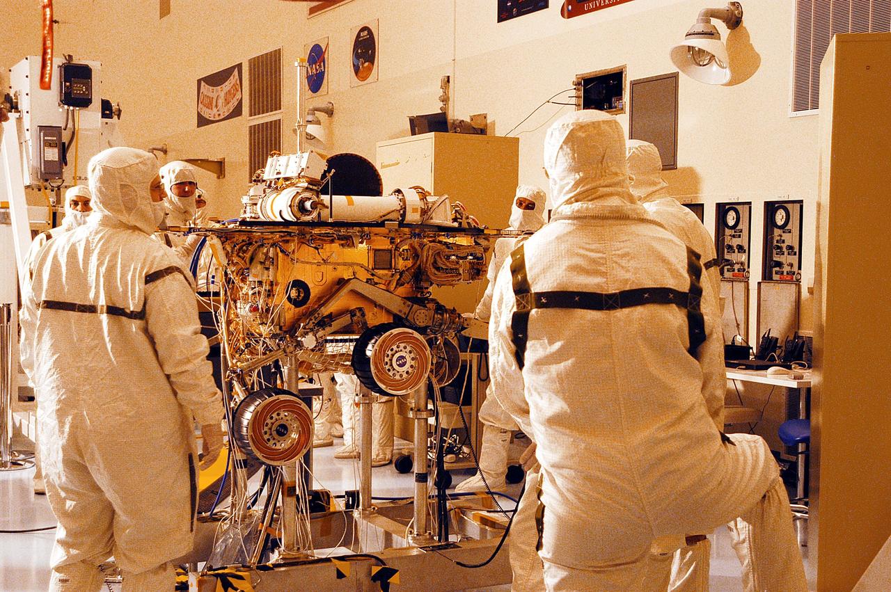 KENNEDY SPACE CENTER, Fla. -  Workers in the Payload Hazardous Servicing Facility observe as one of the two Mars Exploration Rovers, MER-2, undergoes testing.  MER-1 and MER-2, their aeroshells and landers will undergo a full mission simulation before being integrated. After spin balance testing,  each spacecraft will be mated to a solid propellant upper stage booster that will propel the spacecraft out of Earth orbit. Approximately 10 days before launch they will be transported to the launch pad for mating with their respective Boeing Delta II rockets. The rovers will serve as robotic geologists to seek answers about the evolution of Mars, particularly  for a history of water. The rovers are identical to each other, but will land at different regions of Mars.  Launch of the first rover is scheduled for May 30 from Cape Canaveral Air Force Station.  The second will follow June 25.