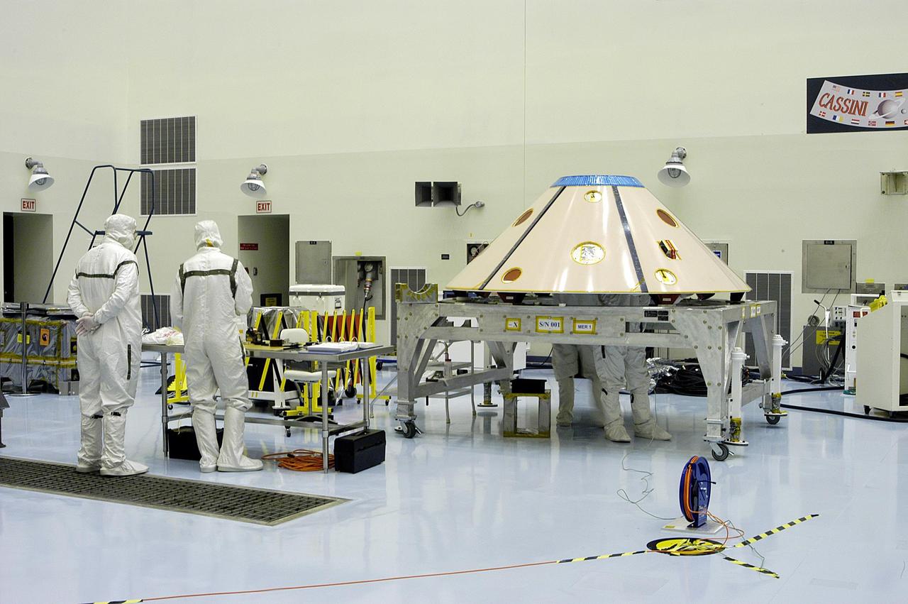 KENNEDY SPACE CENTER, Fla. - In the Payload Hazardous Servicing Facility technicians work on one of the aeroshell assemblies for the Mars Exploration Rovers (MER).  MER-1 and MER-2, their aeroshells and landers will undergo a full mission simulation before being integrated. After spin balance testing,  each spacecraft will be mated to a solid propellant upper stage booster that will propel the spacecraft out of Earth orbit. Approximately 10 days before launch they will be transported to the launch pad for mating with their respective Boeing Delta II rockets. The rovers will serve as robotic geologists to seek answers about the evolution of Mars, particularly  for a history of water. The rovers are identical to each other, but will land at different regions of Mars.  Launch of the first rover is scheduled for May 30 from Cape Canaveral Air Force Station.  The second will follow June 25.