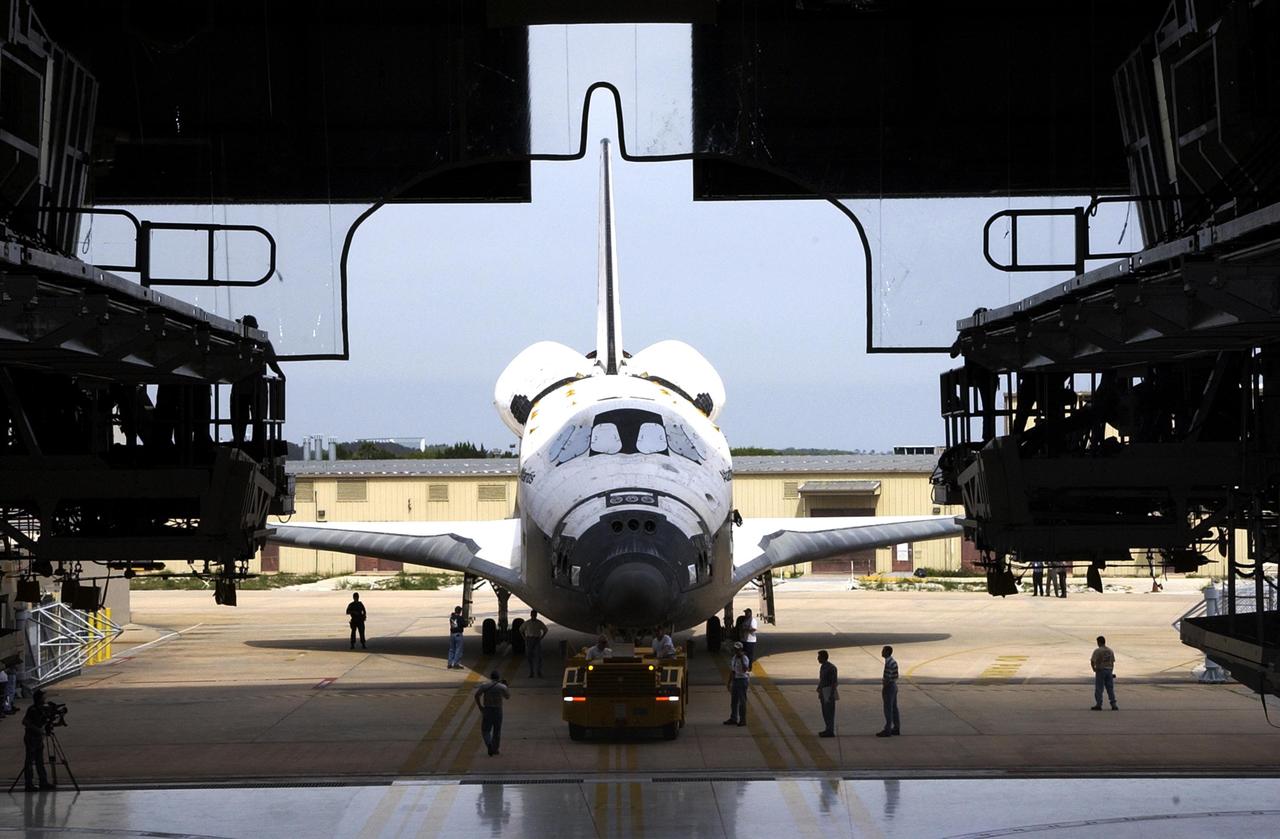 KENNEDY SPACE CENTER, Fla. - Atlantis is towed away from the Vehicle Assembly Building. The orbiter was demated from its external tank in the high bay, lifted over the transom, then lowered and shifted to the horizontal position in the transfer aisle. Atlantis is being moved to the Orbiter Processing Facility.