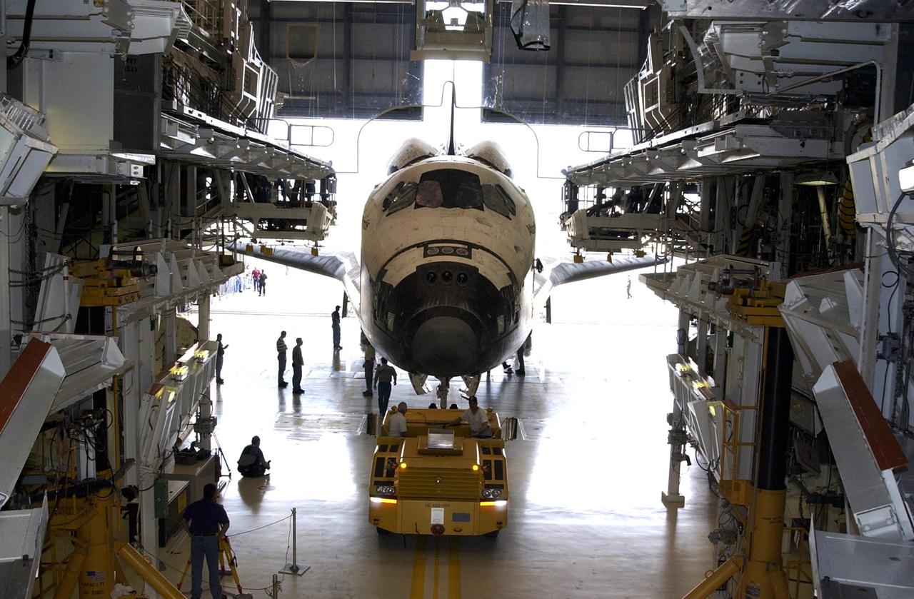 KENNEDY SPACE CENTER, Fla. - Atlantis is towed away from the Vehicle Assembly Building. The orbiter was demated from its external tank in the high bay, lifted over the transom, then lowered and shifted to the horizontal position in the transfer aisle. Atlantis is being moved to the Orbiter Processing Facility.