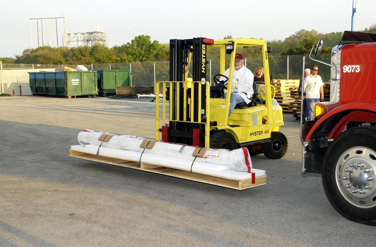 KENNEDY SPACE CENTER, Fla. - A piece of Columbia debris is offloaded from the truck and moved toward the KSC RLV Hangar. Inside, the Columbia Reconstruction Project Team is identifying pieces and placing them on a floor grid in a configuration of the orbiter. The team will attempt to reconstruct the bottom of the orbiter as part of the investigation into the accident that caused the destruction of Columbia and loss of its crew as it returned to Earth on mission STS-107. To date, 35,319 pieces have been shipped to KSC; 1,218 are identified and placed on the grid.
