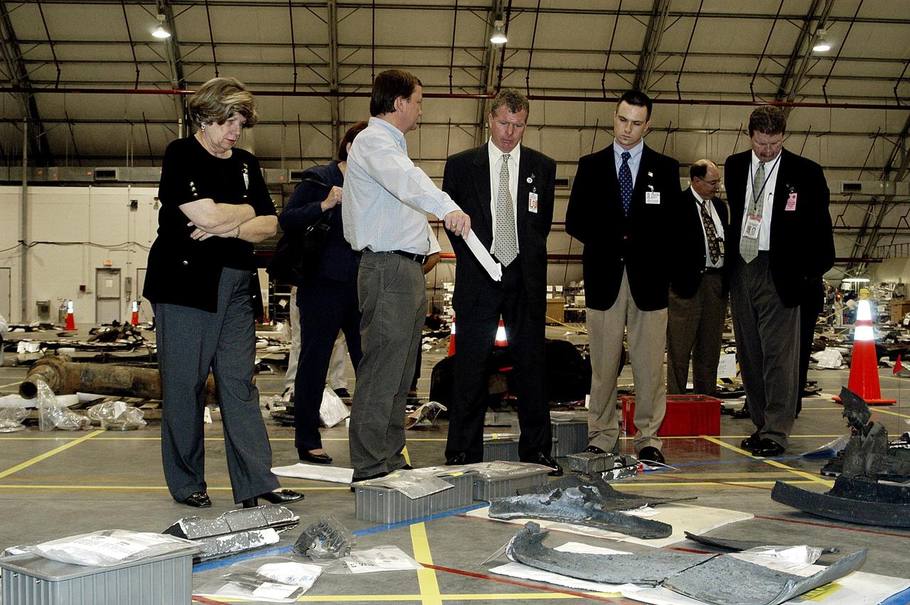 KENNEDY SPACE CENTER, FLA. - Mike Leinbach, Shuttle launch director, points out a piece of debris to U.S. Representative Tom Feeney (third from right) along with his staff.  They are visiting KSC to see the Columbia debris collected in the RLV Hangar.  At far left is JoAnn Morgan, KSC's director of External Relations and Business Development.  At far right is John Halsema, Chief/Federal & International Liaison, Government Relations Office