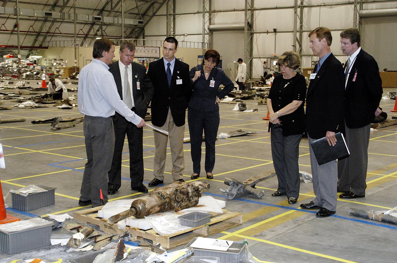 KENNEDY SPACE CENTER, Fla. -  In the RLV Hangar, Mike Leinbach, Shuttle launch director, describes some of the debris to U.S. Representative Tom Feeney (second from left), who is visiting KSC to see the Columbia debris collected in the hangar.  At right, from KSC, are JoAnn Morgan, director of External Relations and Business Development; Greg Katnik, technical manager, Space Shuttle Program Launch Integration Office; and John Halsema, Chief/Federal & International Liaison, Government Relations Office.