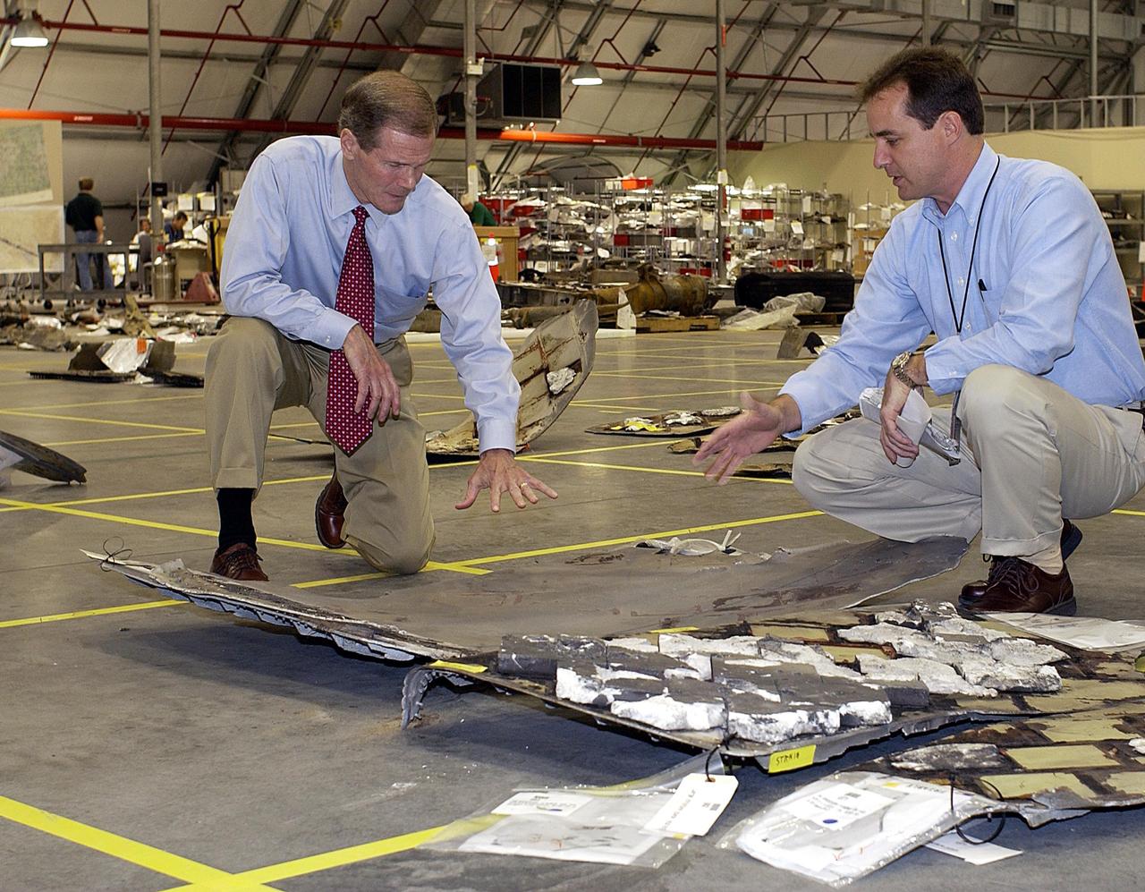 KENNEDY SPACE CENTER, FLA. --  U.S. Senator Bill Nelson and Space Shuttle Test Director Steve Altemus look at Columbia debris in KSC's RLV Hangar.