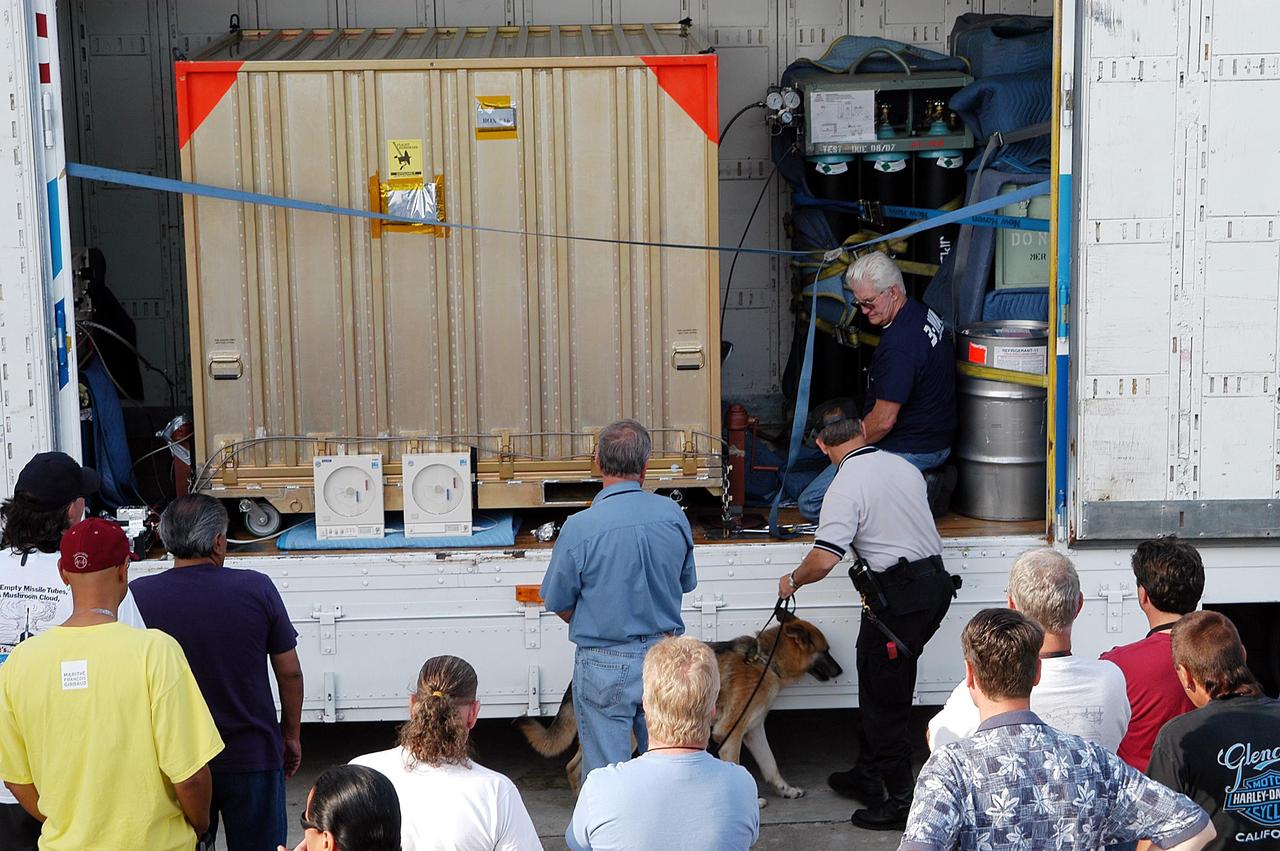 KENNEDY SPACE CENTER, Fla. - Outside the Payload Hazardous Servicing Facility, the open door of the transport shows the shipping container with the second Mars Exploration Rover (MER-1) inside. MER-2 and other hardware have already arrived at KSC for processing. While at KSC, each of the rovers, their aeroshells and landers will undergo a full mission simulation. After spin balance testing, each spacecraft will be mated to a solid propellant upper stage booster that will propel the spacecraft out of Earth orbit. Approximately 10 days before launch they will be transported to the launch pad for mating with their respective Boeing Delta II rockets. The rovers will serve as robotic geologists to seek answers about the evolution of Mars, particularly for a history of water. The rovers are identical to each other, and will land at different regions of Mars. Launch of the MER-1 is scheduled for May 30. MER-2 will follow June 25.