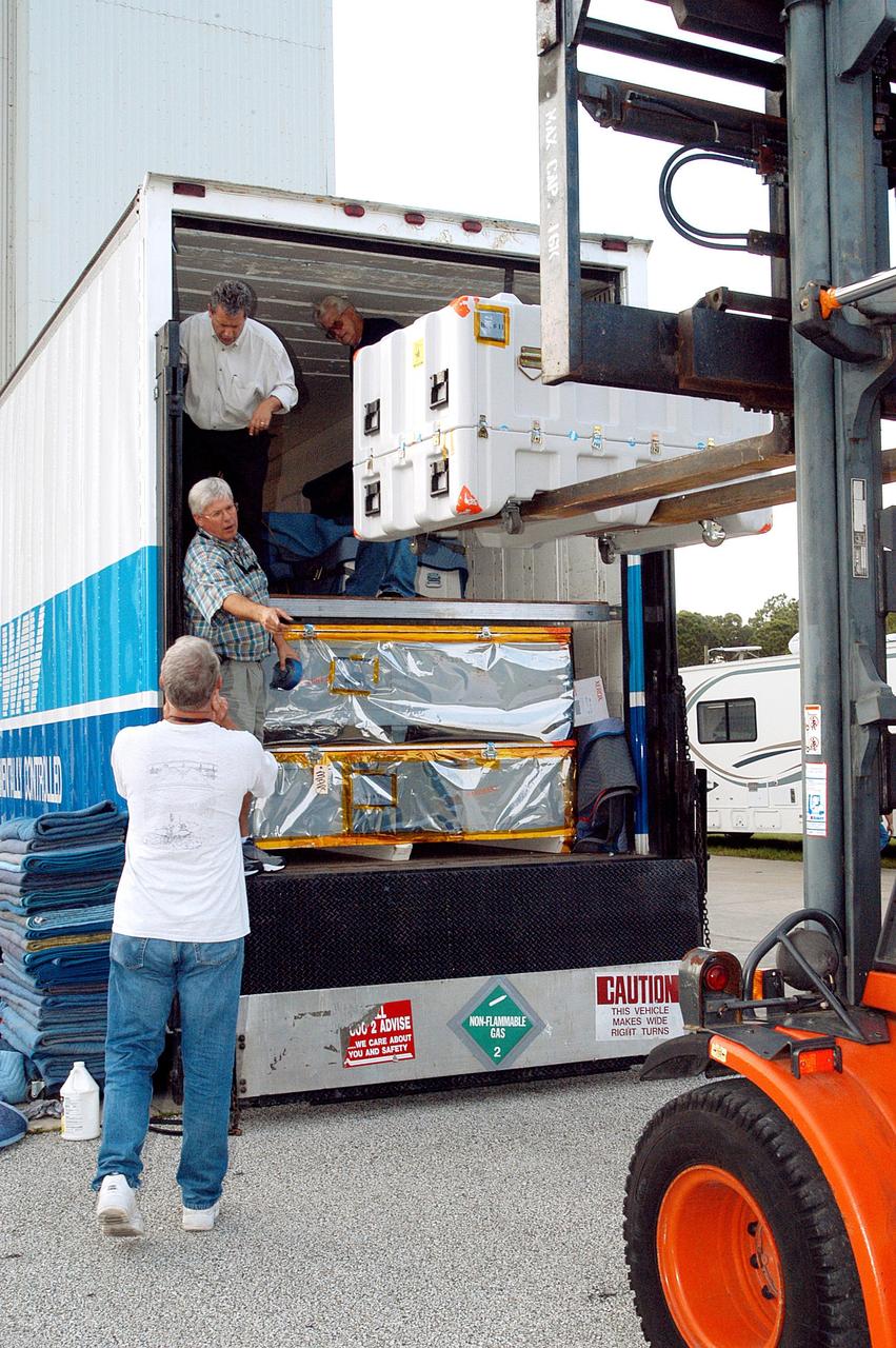 KENNEDY SPACE CENTER, Fla. - Outside the Payload Hazardous Servicing Facility hardware related to the Mars Exploration Rovers (MER) is offloaded from a transport vehicle. MER-1 will undergo prelaunch testing, including deployment of the lander petals, the rover's solar arrays, camera mast and camera. While at KSC, MER-1 and MER-2, their aeroshells and landers will undergo a full mission simulation. After spin balance testing, each spacecraft will be mated to a solid propellant upper stage booster that will propel the spacecraft out of Earth orbit. Approximately 10 days before launch they will be transported to the launch pad for mating with their respective Boeing Delta II rockets. The rovers will serve as robotic geologists to seek answers about the evolution of Mars, particularly for a history of water. The rovers are identical to each other, and will land at different regions of Mars. Launch of the MER-1 is scheduled for May 30. MER-2 will follow June 25.