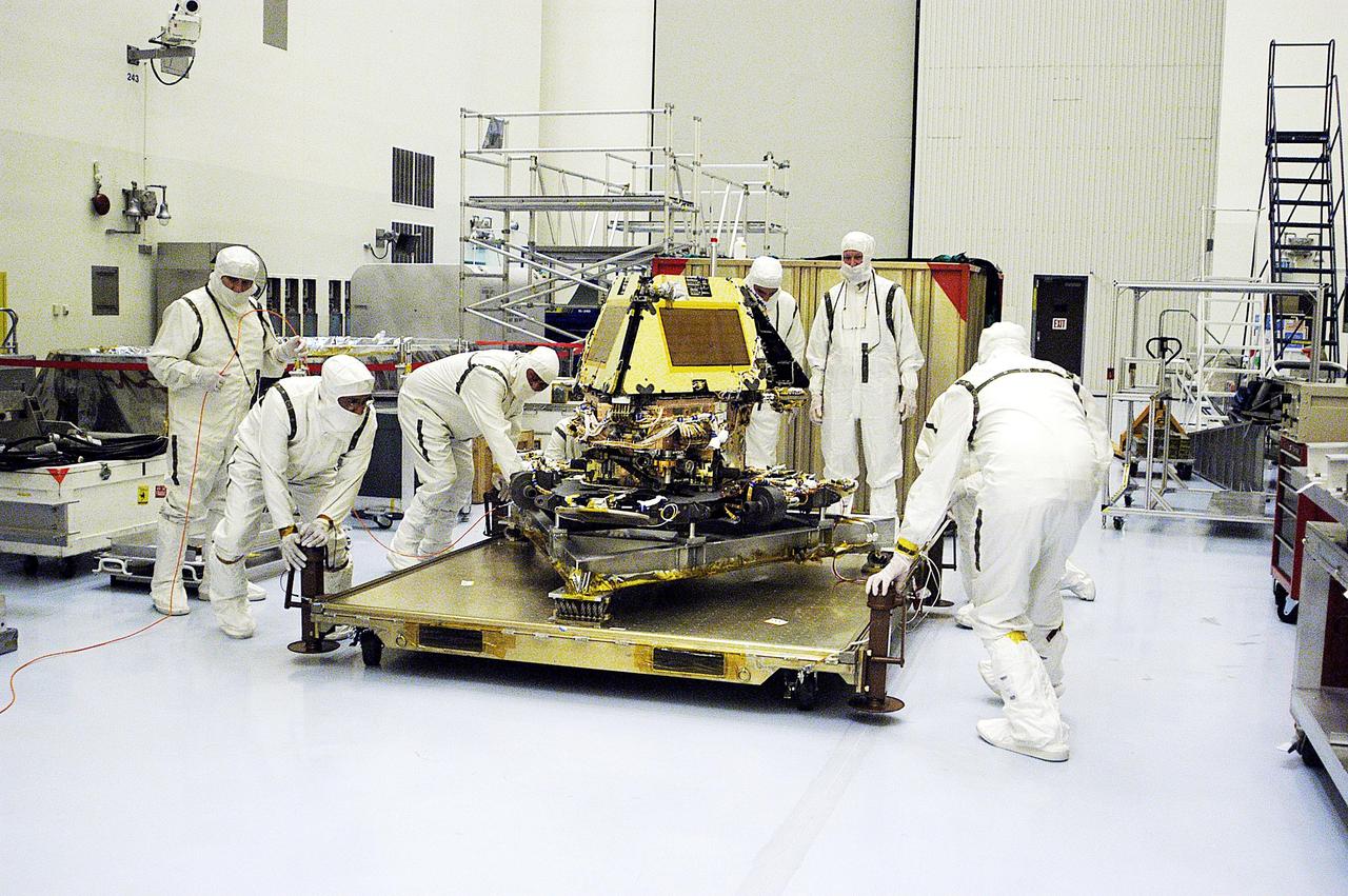KENNEDY SPACE CENTER, Fla. - In the Payload Hazardous Servicing Facility, workers appear to adjust the platform holding the second Mars Exploration Rover, MER-1. It will undergo prelaunch testing, including deployment of the lander petals, the rover's solar arrays, camera mast and camera. While at KSC, each of the rovers, their aeroshells and landers will undergo a full mission simulation. After spin balance testing, each spacecraft will be mated to a solid propellant upper stage booster that will propel the spacecraft out of Earth orbit. Approximately 10 days before launch they will be transported to the launch pad for mating with their respective Boeing Delta II rockets. The rovers will serve as robotic geologists to seek answers about the evolution of Mars, particularly for a history of water. The rovers are identical to each other, and will land at different regions of Mars. Launch of the MER-1 is scheduled for May 30. MER-2 will follow June 25.