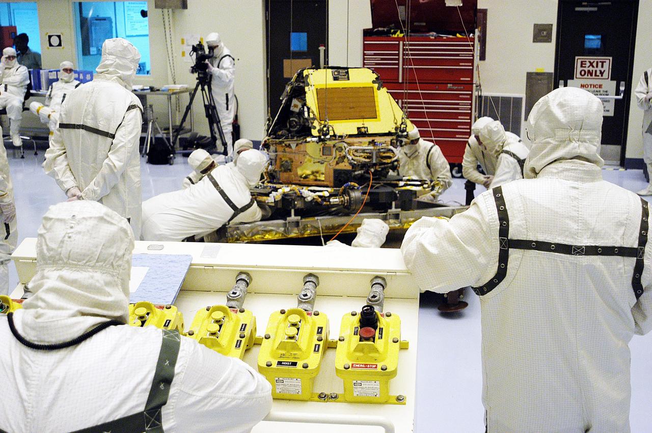 KENNEDY SPACE CENTER, Fla. - Workers in the Payload Hazardous Servicing Facility look over Mars Exploration Rover-1, which is ready for prelaunch testing including deployment of the lander petals, the rover's solar arrays, camera mast and camera. While at KSC, each of the two rovers, their aeroshells and landers will undergo a full mission simulation. After spin balance testing, each spacecraft will be mated to a solid propellant upper stage booster that will propel the spacecraft out of Earth orbit. Approximately 10 days before launch they will be transported to the launch pad for mating with their respective Boeing Delta II rockets. The rovers will serve as robotic geologists to seek answers about the evolution of Mars, particularly for a history of water. The rovers are identical to each other, and will land at different regions of Mars. Launch of the MER-1 is scheduled for May 30. MER-2 will follow June 25.