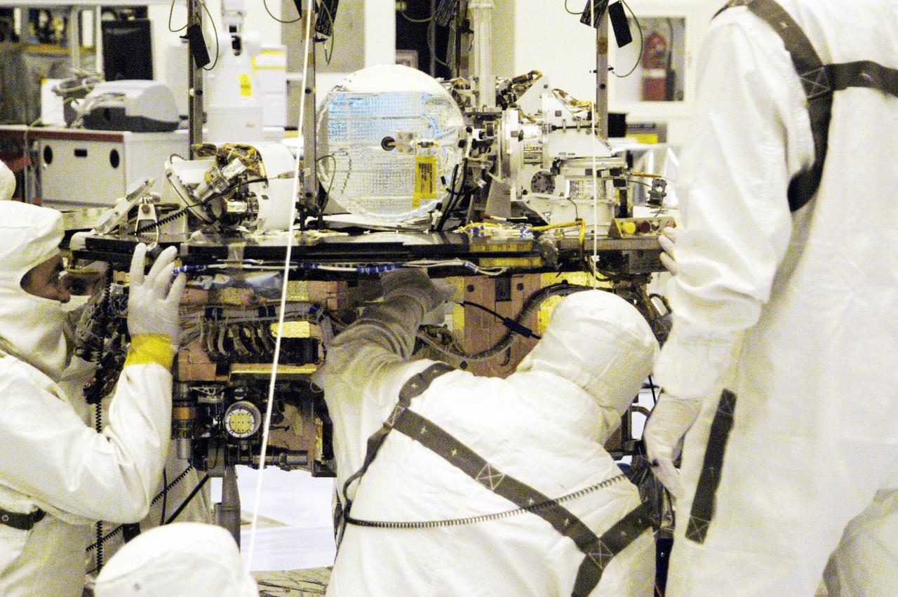 KENNEDY SPACE CENTER, Fla. - In the Payload Hazardous Servicing Facility, workers check alignment of the Rover Equipment Deck (RED) on one of the Mars Exploration Rovers (MER) with the Warm Electronics Box (WEB). Processing of the rovers, plus cruise stage, lander and heat shield elements, is ongoing. Set to launch in 2003, the MER Mission will consist of two identical rovers designed to cover roughly 110 yards each Martian day. Each rover will carry five scientific instruments that will allow it to search for evidence of liquid water that may have been present in the planet's past. The rovers will be identical to each other, but will land at different regions of Mars. The first rover has a launch window opening May 30, and the second rover a window opening June 25, 2003.