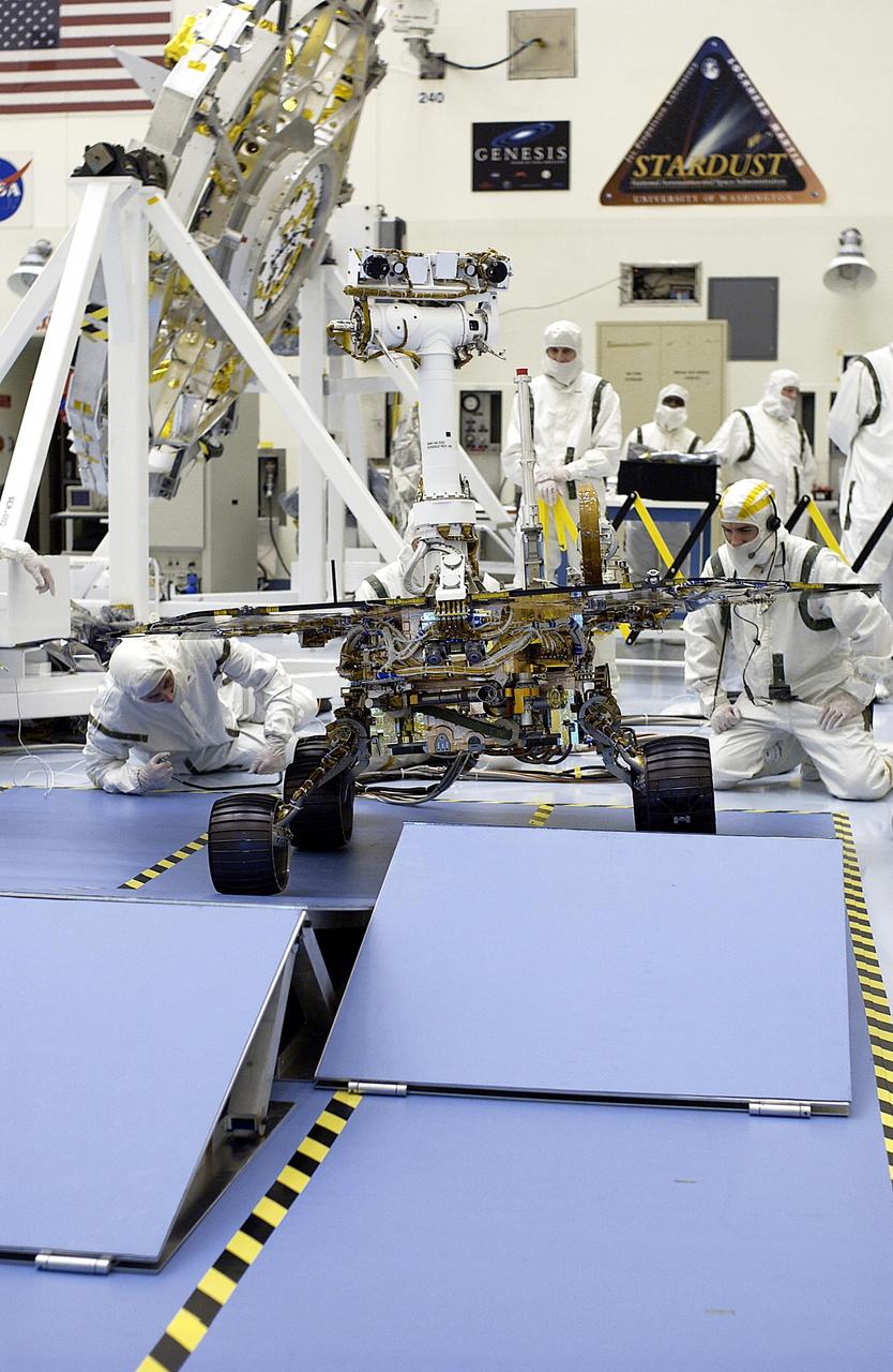 KENNEDY SPACE CENTER, Fla. - In the Payload Hazardous Servicing Facility, workers watch as the Mars Exploration Rover-2 (MER-2) rolls over ramps to test its mobility and maneuverability. Set to launch in Spring 2003, the MER Mission will consist of two identical rovers designed to cover roughly 110 yards each Martian day over various terrain. Each rover will carry five scientific instruments that will allow it to search for evidence of liquid water that may have been present in the planet's past. The rovers will be identical to each other, but will land at different regions of Mars. The first rover has a launch window opening May 30, and the second rover a window opening June 25.