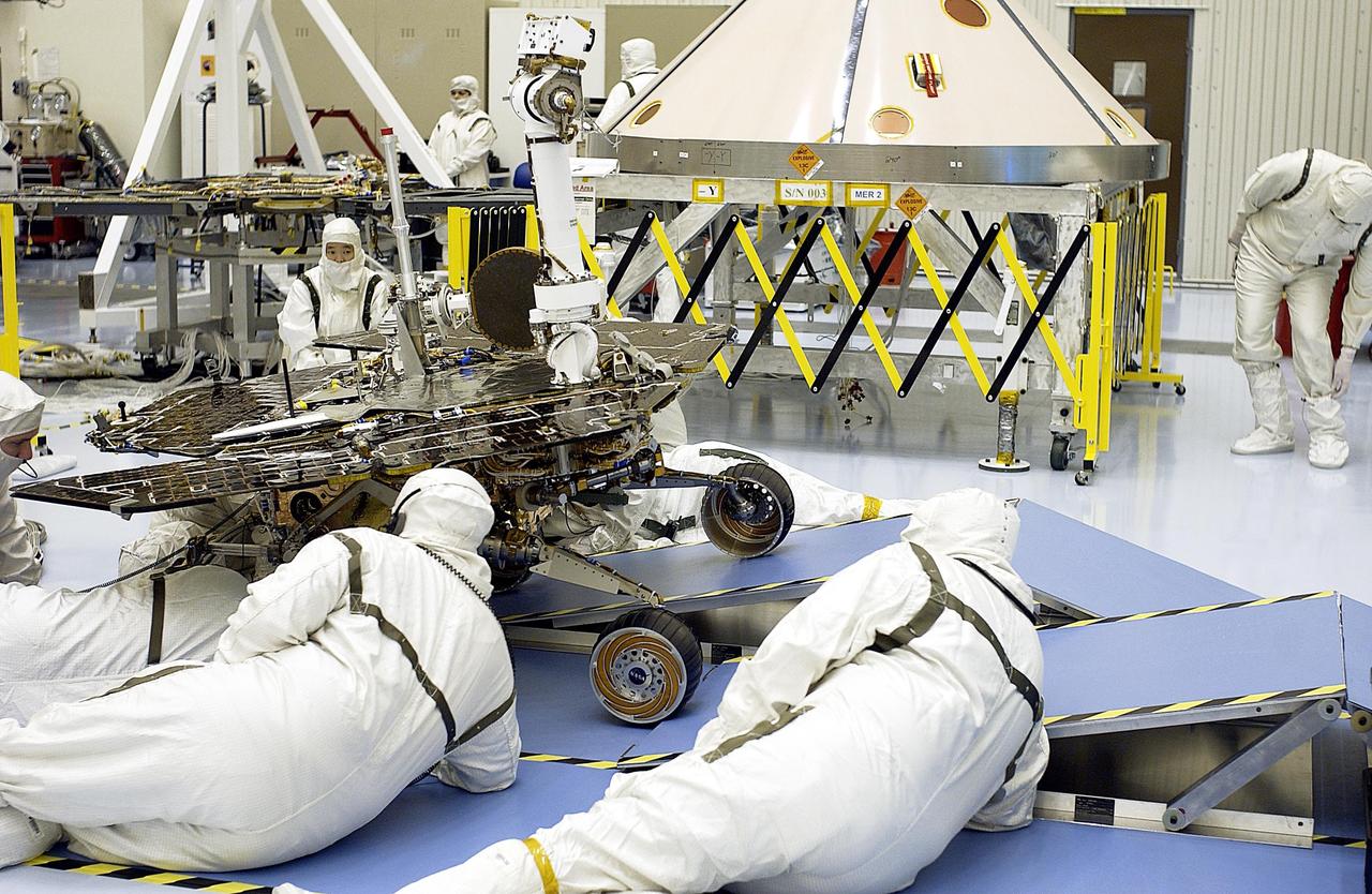 KENNEDY SPACE CENTER, Fla. - In the Payload Hazardous Servicing Facility, workers check the progress of the Mars Exploration Rover-2 (MER-2) as it rolls over ramps to test its mobility and maneuverability. Set to launch in Spring 2003, the MER Mission will consist of two identical rovers designed to cover roughly 110 yards each Martian day over various terrain. Each rover will carry five scientific instruments that will allow it to search for evidence of liquid water that may have been present in the planet's past. The rovers will be identical to each other, but will land at different regions of Mars. The first rover has a launch window opening May 30, and the second rover a window opening June 25.