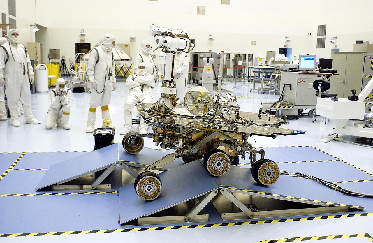 KENNEDY SPACE CENTER, Fla. - In the Payload Hazardous Servicing Facility, workers watch as the Mars Exploration Rover-2 (MER-2) rolls over ramps to test its mobility and maneuverability. Set to launch in Spring 2003, the MER Mission will consist of two identical rovers designed to cover roughly 110 yards each Martian day over various terrain. Each rover will carry five scientific instruments that will allow it to search for evidence of liquid water that may have been present in the planet's past. The rovers will be identical to each other, but will land at different regions of Mars. The first rover has a launch window opening May 30, and the second rover a window opening June 25.