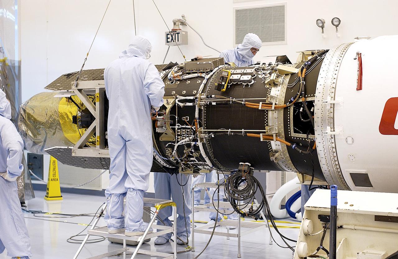 KENNEDY SPACE CENTER, FLA. - Workers in the Multi-Payload Processing Facility prepare to demate the Galaxy Evolution Explorer (GALEX) spacecraft from the Pegasus XL launch vehicle. Foreign object debris shields will be installed before its launch. The GALEX is an orbiting space telescope that will observe galaxies in ultraviolet light across 10 billion years of cosmic history. During its 29-month mission GALEX will produce the first comprehensive map of a Universe of galaxies under construction, bringing more understanding how galaxies like the Milky Way were formed. The GALEX launch date is under review.