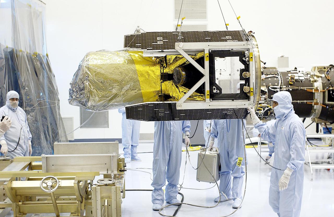 KENNEDY SPACE CENTER, Fla. - The Galaxy Evolution Explorer (GALEX) spacecraft is moved toward a work stand (in the foreground). Foreign object debris shields will be installed before its launch. The GALEX is an orbiting space telescope that will observe galaxies in ultraviolet light across 10 billion years of cosmic history. During its 29-month mission GALEX will produce the first comprehensive map of a Universe of galaxies under construction, bringing more understanding how galaxies like the Milky Way were formed. The GALEX launch date is under review.