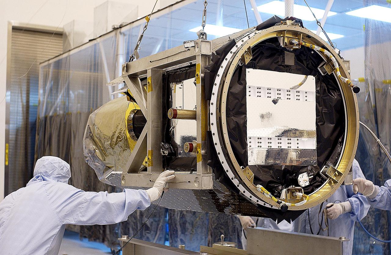 KENNEDY SPACE CENTER, Fla. - The Galaxy Evolution Explorer (GALEX) spacecraft is lowered toward a work stand. Foreign object debris shields will be installed before its launch. The GALEX is an orbiting space telescope that will observe galaxies in ultraviolet light across 10 billion years of cosmic history. During its 29-month mission GALEX will produce the first comprehensive map of a Universe of galaxies under construction, bringing more understanding how galaxies like the Milky Way were formed. The GALEX launch date is under review.