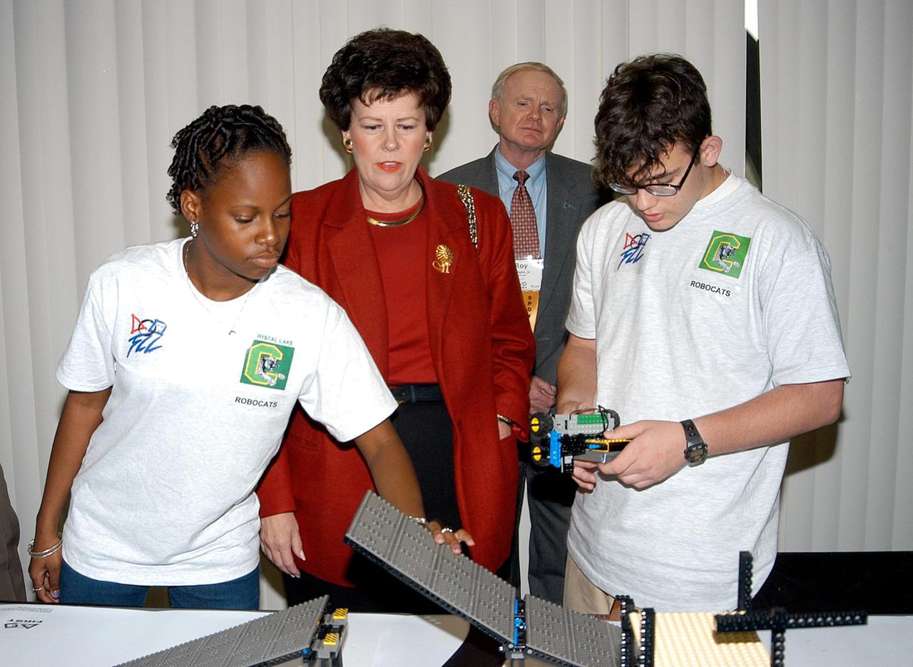 KENNEDY SPACE CENTER, FLA. - NASA/Kennedy Space Center Director Roy Bridges (background) observes as Florida Lt. Gov. Toni Jennings interacts with students at a display of space structures built from Lego blocks at the 2003 Southeastern Regional FIRST Robotic Competition. The competition is being held at the University of Central Florida (UCF) in Orlando, March 20-23. Forty student teams from around the country are participating in the event that pits team-built gladiator robots against each other in an athletic-style competition. The teams are sponsored by NASA/Kennedy Space Center, The Boeing Company/Brevard Community College, and Lockheed Martin Space Operations/Mission Systems for the nonprofit organization For Inspiration and Recognition of Science and Technology, known as FIRST. The vision of FIRST is to inspire in the youth of our nation an appreciation of science and technology and an understanding that mastering these disciplines can enrich the lives of all mankind.