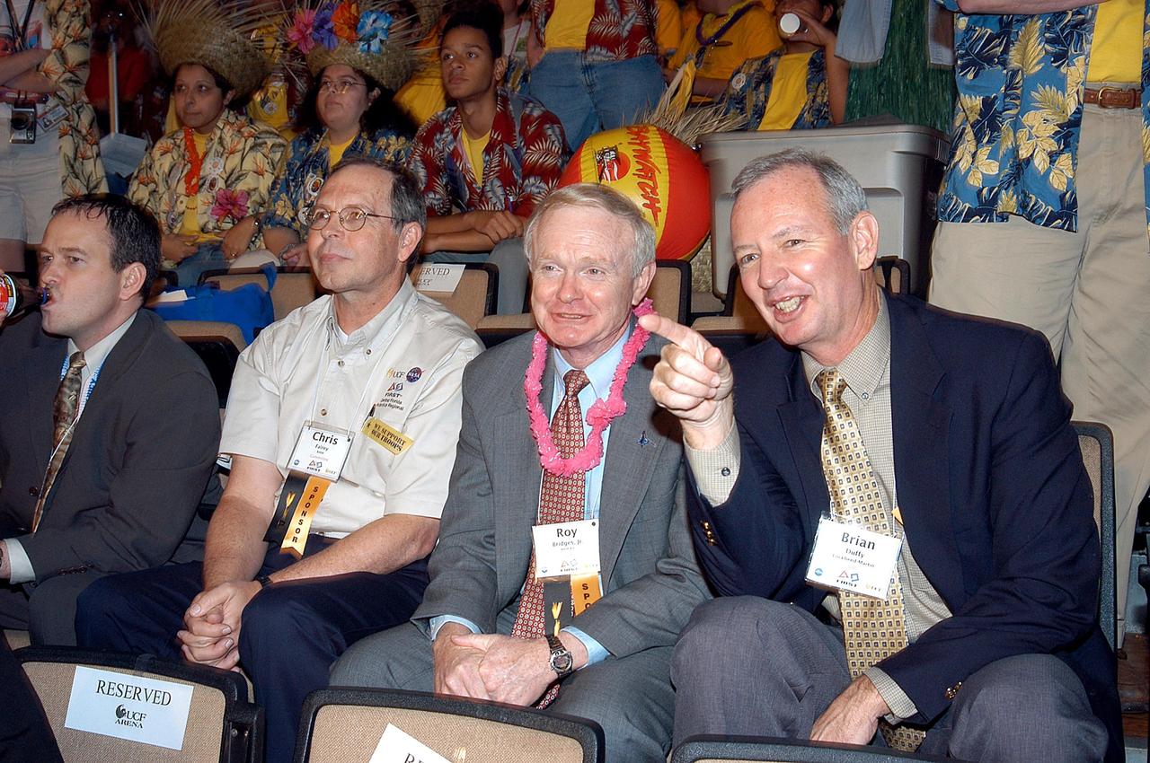 KENNEDY SPACE CENTER, FLA. -  Observing the festivities at the 2003 Southeastern Regional FIRST Robotic Competition are, from left, David Culp, executive intern to the director of KSC; Chris Fairey, former director of Spaceport Services at KSC; Roy Bridges, KSC director; and Brian Duffy, Lockheed Martin vice president/associate program manager. The competition is being held at the University of Central Florida (UCF) in Orlando, March 20-23. Forty student teams from around the country are participating in the event that pits team-built gladiator robots against each other in an athletic-style competition. The teams are sponsored by NASA/Kennedy Space Center, The Boeing Company/Brevard Community College, and Lockheed Martin Space Operations/Mission Systems for the nonprofit organization For Inspiration and Recognition of Science and Technology, known as FIRST. The vision of FIRST is to inspire in the youth of our nation an appreciation of science and technology and an understanding that mastering these disciplines can enrich the lives of all mankind.