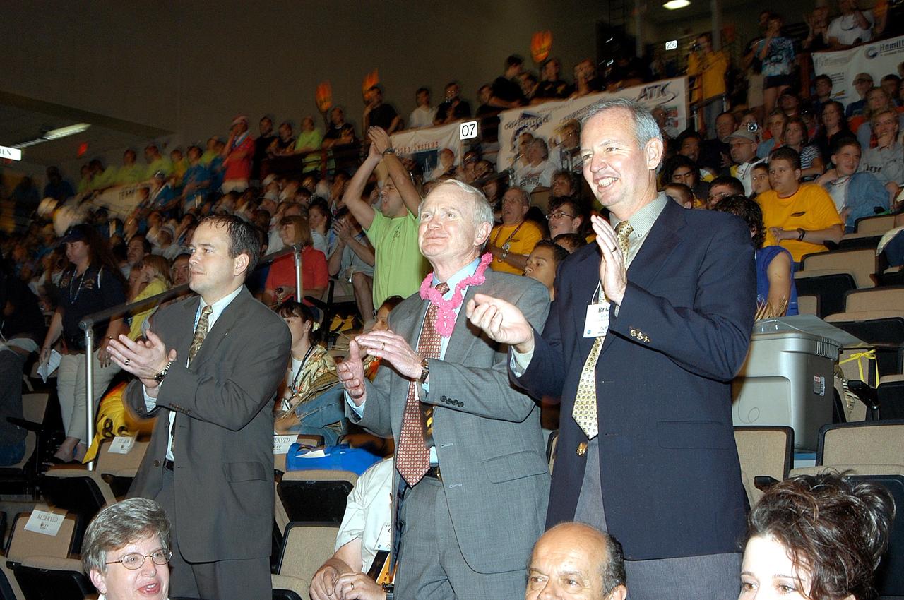 KENNEDY SPACE CENTER, FLA. -  On their feet, applauding the student participants of the 2003 Southeastern Regional FIRST Robotic Competition are, from left, David Culp, executive intern to the director of KSC; Roy Bridges, KSC director; and Brian Duffy, Lockheed Martin vice president/associate program manager. The competition is being held at the University of Central Florida (UCF) in Orlando, March 20-23. Forty student teams from around the country are participating in the event that pits team-built gladiator robots against each other in an athletic-style competition. The teams are sponsored by NASA/Kennedy Space Center, The Boeing Company/Brevard Community College, and Lockheed Martin Space Operations/Mission Systems for the nonprofit organization For Inspiration and Recognition of Science and Technology, known as FIRST. The vision of FIRST is to inspire in the youth of our nation an appreciation of science and technology and an understanding that mastering these disciplines can enrich the lives of all mankind.
