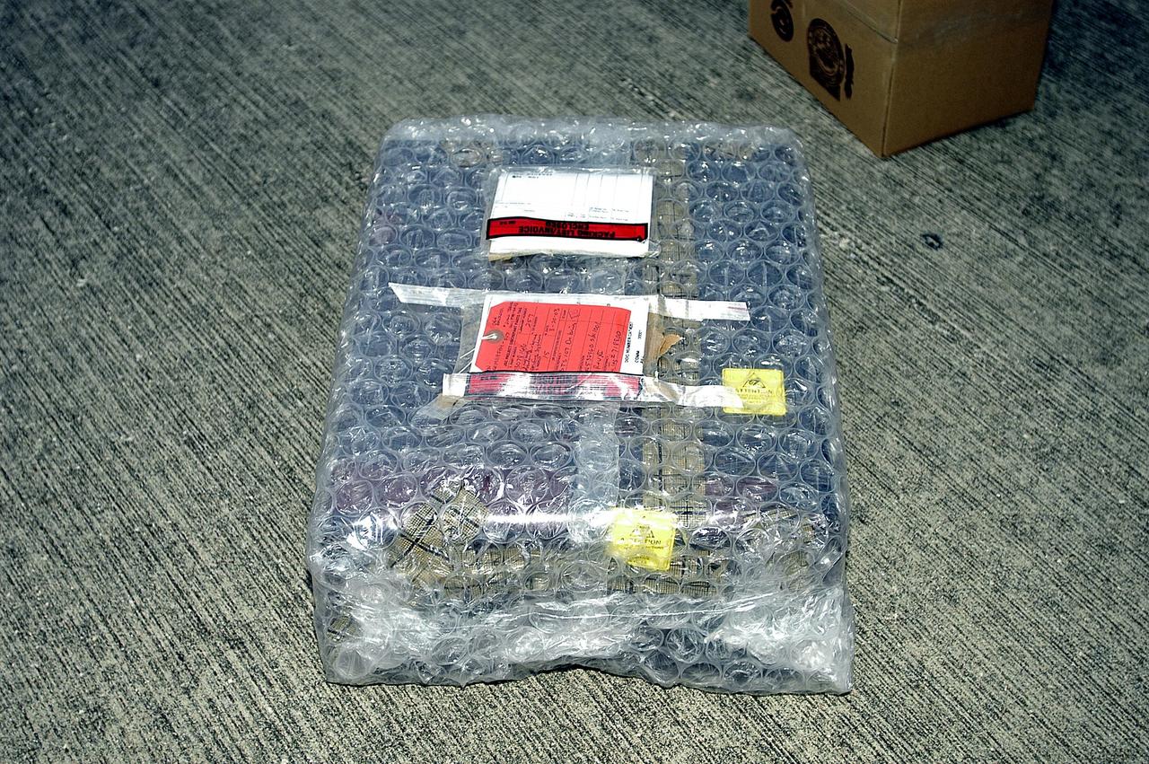 KENNEDY SPACE CENTER, FLA. -  The Orbiter Experiment Support System (OEX) recorder from Columbia, in protective covering, sits on the pavement after its arrival at KSC aboard a T-38 jet aircraft.   Search teams near Hemphill, Texas, recovered the recorder, which stores sensor information about temperature, aerodynamic pressure, vibrations and other data from dozens of sensor locations on the orbiter, operating only during launch and re-entry. The OEX uses magnetic tape to record data that is not sent to the ground by telemetry.