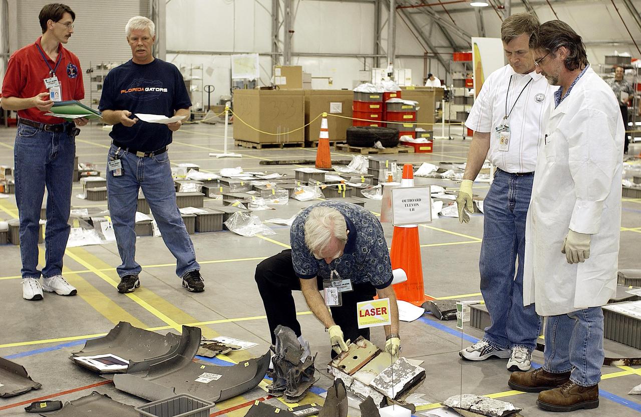 KENNEDY SPACE CENTER, FLA. -  A new piece of Columbia debris is placed on the floor of the RLV Hangar.  The Columbia Reconstruction Project team is identifying pieces and placing them on a grid approximating the shape of the orbiter.  About 25 percent of the orbiter has been delivered to the hangar.