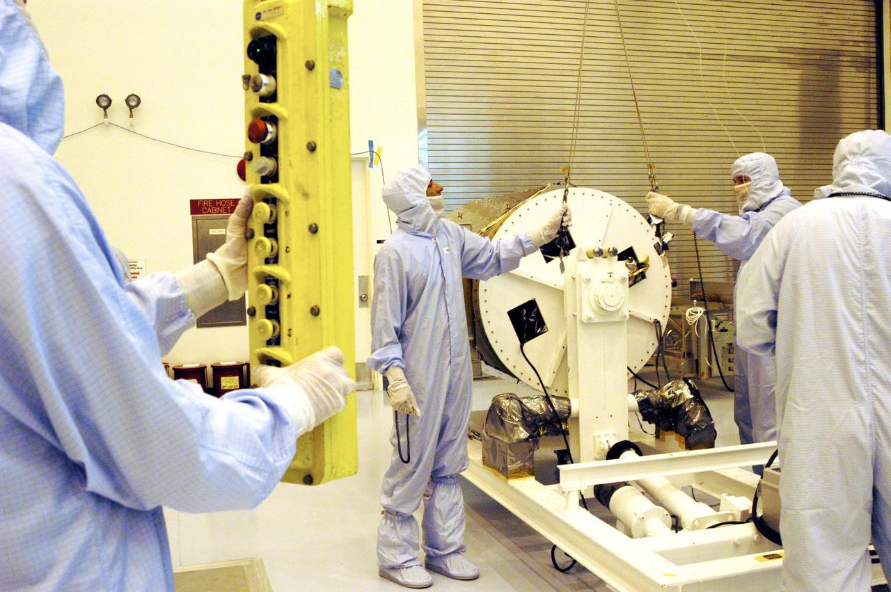 KENNEDY SPACE CENTER, FLA. -  Technicians prepare to lift the Galaxy Evolution Explorer (GALEX) spacecraft into a vertical position after it is demated from its Pegasus launch vehicle in the Payload Hazardous Servicing Facility. A borescope inspection will be conducted to locate a small fastener and associated clip missing from a demated connector identified during preflight testing. GALEX is an orbiting space telescope that will observe galaxies in ultraviolet light across 10 billion years of cosmic history. During its 29-month mission, GALEX will produce the first comprehensive map of a Universe of galaxies under construction, bringing more understanding to how galaxies like the Milky Way were formed. The GALEX launch date in late April is currently under review.