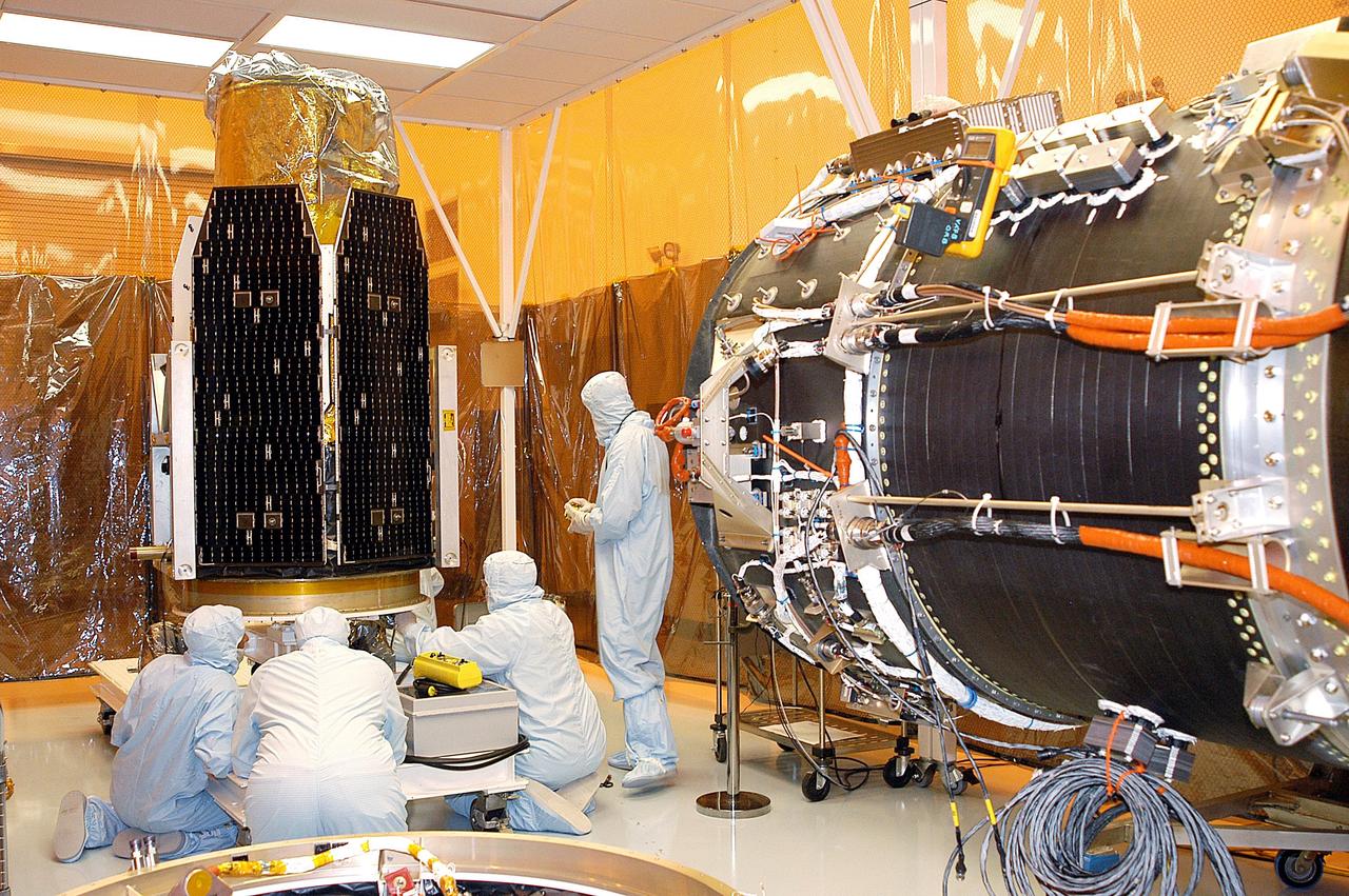 KENNEDY SPACE CENTER, FLA. -  The Galaxy Evolution Explorer (GALEX) spacecraft awaits inspection after being moved into a vertical position in the Payload Hazardous Servicing Facility.  On the right is the Pegasus launch vehicle from which it was demated. A borescope inspection will be conducted on the spacecraft to locate a small fastener and associated clip missing from a demated connector identified during preflight testing.  GALEX is an orbiting space telescope that will observe galaxies in ultraviolet light across 10 billion years of cosmic history. During its 29-month mission, GALEX will produce the first comprehensive map of a Universe of galaxies under construction, bringing more understanding to how galaxies like the Milky Way were formed. The GALEX launch date in late April is currently under review.