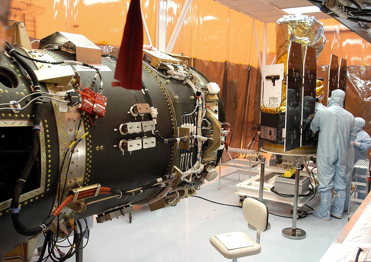 KENNEDY SPACE CENTER, FLA. -  Foreign object debris shields are installed and a borescope inspection is conducted on the Galaxy Evolution Explorer (GALEX) spacecraft in the Payload Hazardous Servicing Facility.  On the left is the Pegasus launch vehicle from which it was demated. Technicians are looking for a small fastener and associated clip missing from a demated connector identified during preflight testing. GALEX is an orbiting space telescope that will observe galaxies in ultraviolet light across 10 billion years of cosmic history. During its 29-month mission, GALEX will produce the first comprehensive map of a Universe of galaxies under construction, bringing more understanding to how galaxies like the Milky Way were formed. The GALEX launch date in late April is currently under review.