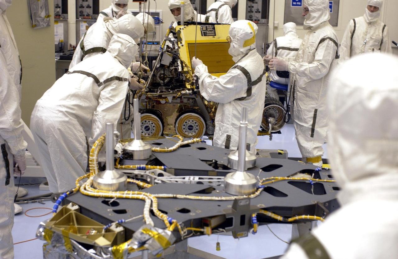 KENNEDY SPACE CENTER, FLA. -  In the Payload Hazardous Servicing Facility, workers prepare to move the Mars Exploration Rover-2 (MER-2) onto the base petal of its lander assembly. Set to launch in Spring 2003, the MER Mission will consist of two identical rovers designed to cover roughly 110 yards each Martian day over various terrain. Each rover will carry five scientific instruments that will allow it to search for evidence of liquid water that may have been present in the planet's past. The rovers will be identical to each other, but will land at different regions of Mars. The first rover has a launch window opening May 30, and the second rover, a window opening June 25.