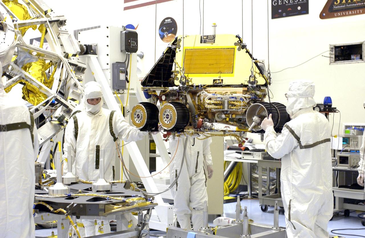 KENNEDY SPACE CENTER, FLA. -  In the Payload Hazardous Servicing Facility, workers move the Mars Exploration Rover-2 (MER-2) towards the base petal of its lander assembly. Set to launch in Spring 2003, the MER Mission will consist of two identical rovers designed to cover roughly 110 yards each Martian day over various terrain. Each rover will carry five scientific instruments that will allow it to search for evidence of liquid water that may have been present in the planet's past. The rovers will be identical to each other, but will land at different regions of Mars. The first rover has a launch window opening May 30, and the second rover, a window opening June 25.