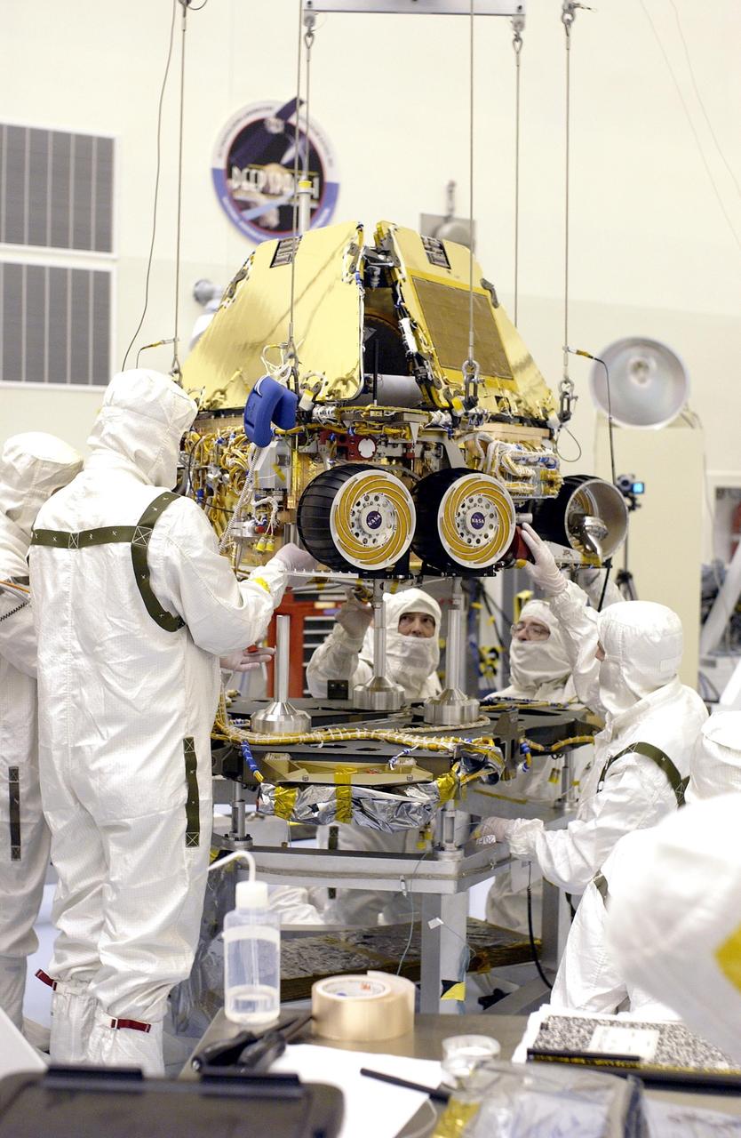 KENNEDY SPACE CENTER, FLA. -  In the Payload Hazardous Servicing Facility, workers lower the Mars Exploration Rover-2 (MER-2) onto the base petal of its lander assembly. Set to launch in Spring 2003, the MER Mission will consist of two identical rovers designed to cover roughly 110 yards each Martian day over various terrain. Each rover will carry five scientific instruments that will allow it to search for evidence of liquid water that may have been present in the planet's past. The rovers will be identical to each other, but will land at different regions of Mars. The first rover has a launch window opening May 30, and the second rover, a window opening June 25.