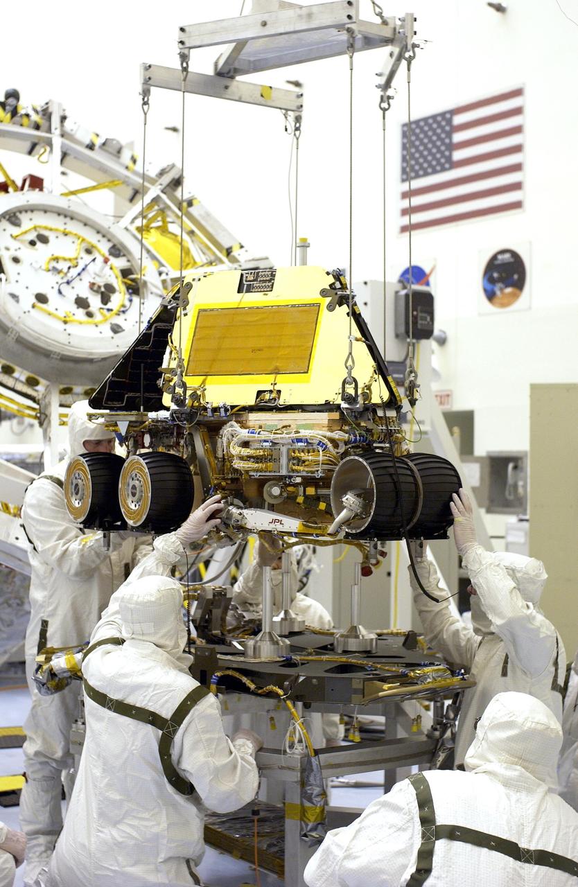 KENNEDY SPACE CENTER, FLA. -  In the Payload Hazardous Servicing Facility, workers monitor the alignment of the Mars Exploration Rover-2 (MER-2) as it is lowered onto the base petal of its lander assembly. Set to launch in Spring 2003, the MER Mission will consist of two identical rovers designed to cover roughly 110 yards each Martian day over various terrain. Each rover will carry five scientific instruments that will allow it to search for evidence of liquid water that may have been present in the planet's past. The rovers will be identical to each other, but will land at different regions of Mars. The first rover has a launch window opening May 30, and the second rover, a window opening June 25.