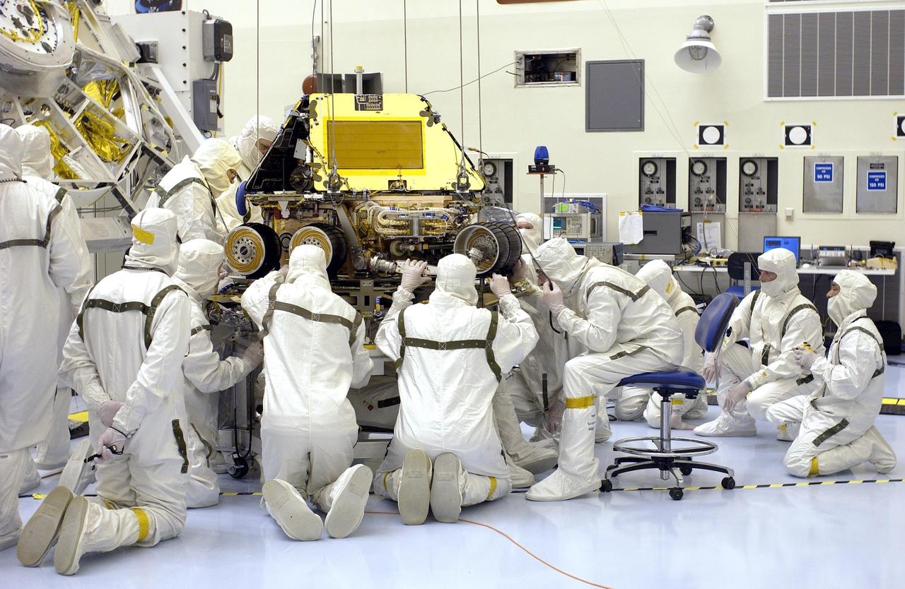 KENNEDY SPACE CENTER, FLA. -  In the Payload Hazardous Servicing Facility, workers check the alignment of the Mars Exploration Rover-2 (MER-2) as it sits on the base petal of its lander assembly. Set to launch in Spring 2003, the MER Mission will consist of two identical rovers designed to cover roughly 110 yards each Martian day over various terrain. Each rover will carry five scientific instruments that will allow it to search for evidence of liquid water that may have been present in the planet's past. The rovers will be identical to each other, but will land at different regions of Mars. The first rover has a launch window opening May 30, and the second rover, a window opening June 25.